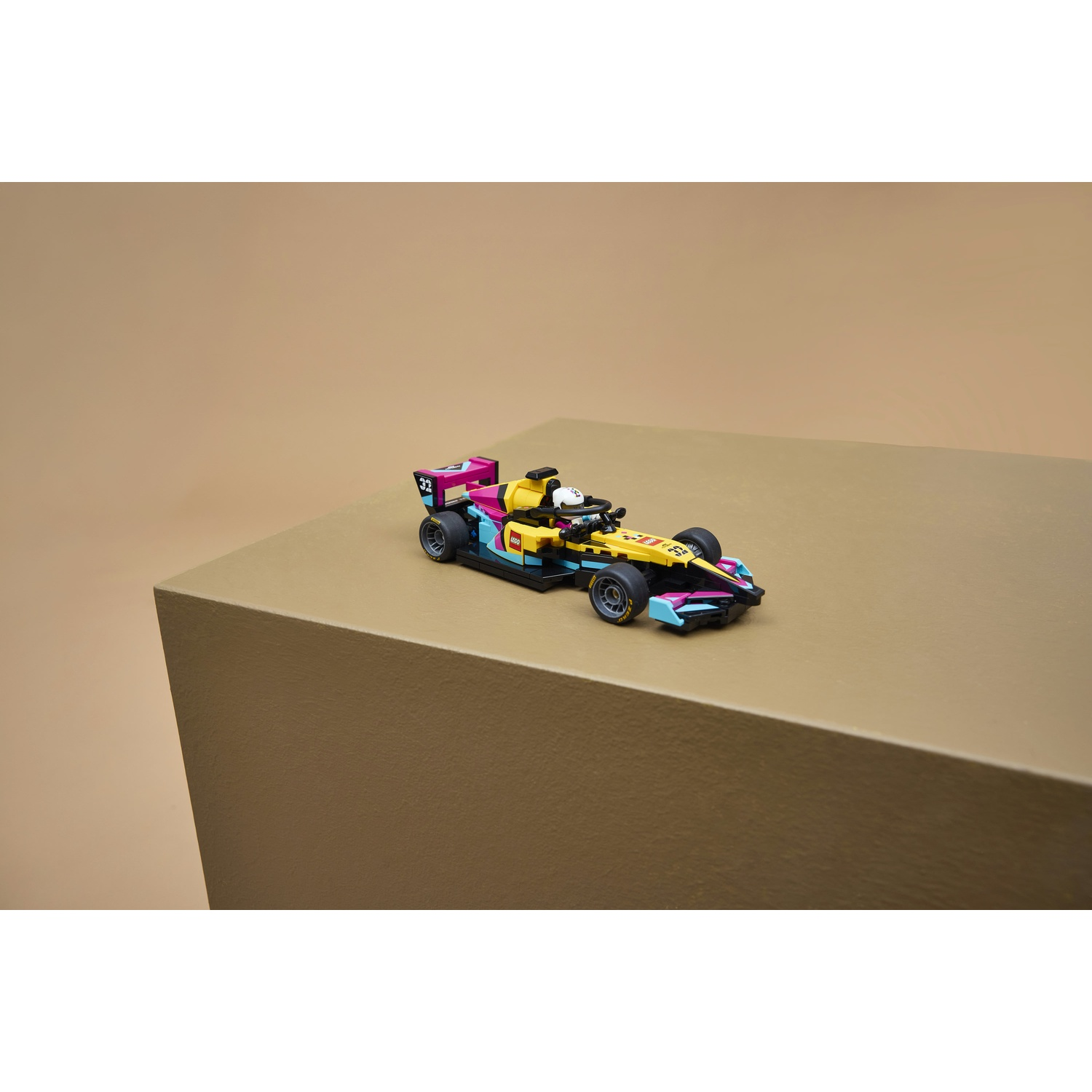 Un'auto da corsa Lego colorata con il numero 32 si trova su una superficie marrone.