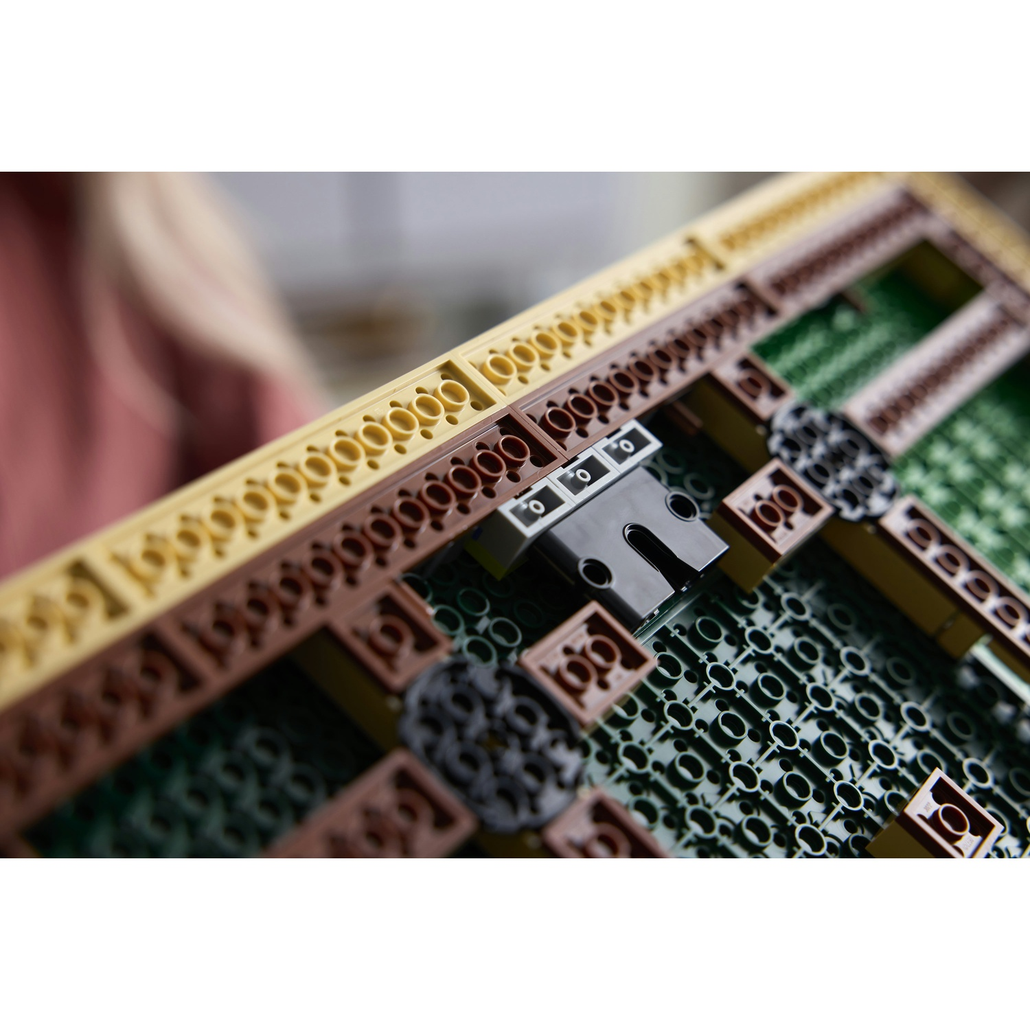 Primo piano di una costruzione Lego gialla e marrone con base verde.