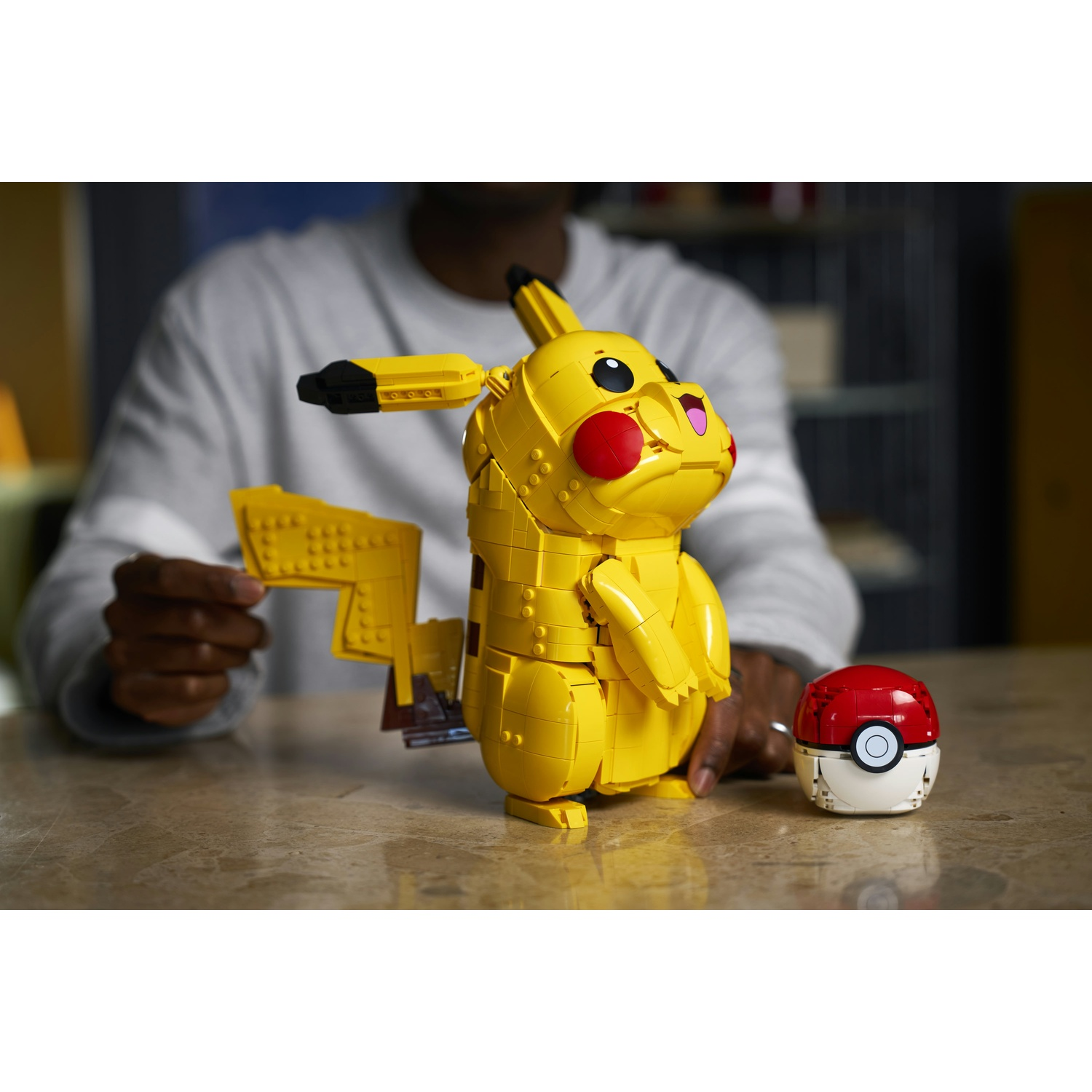 Un Pikachu Lego giallo e un Pokeball su un tavolo.