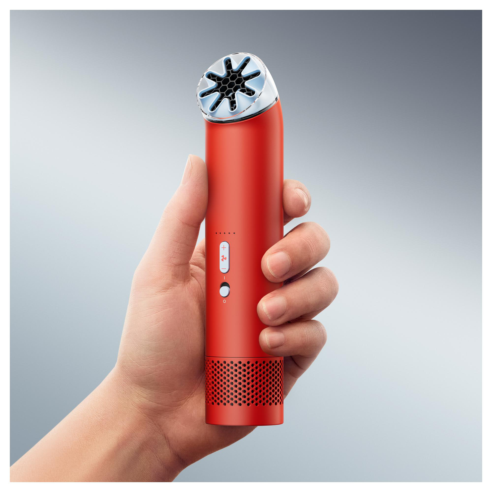 Eine Hand hält ein rotes Gerät mit Lüftungsschlitzen oben und unten.