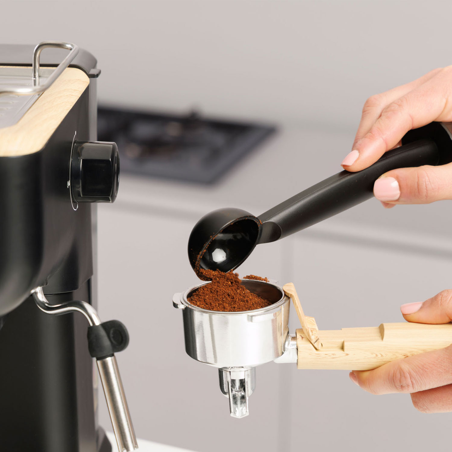 El café molido se vierte en un portafiltro con una cuchara.