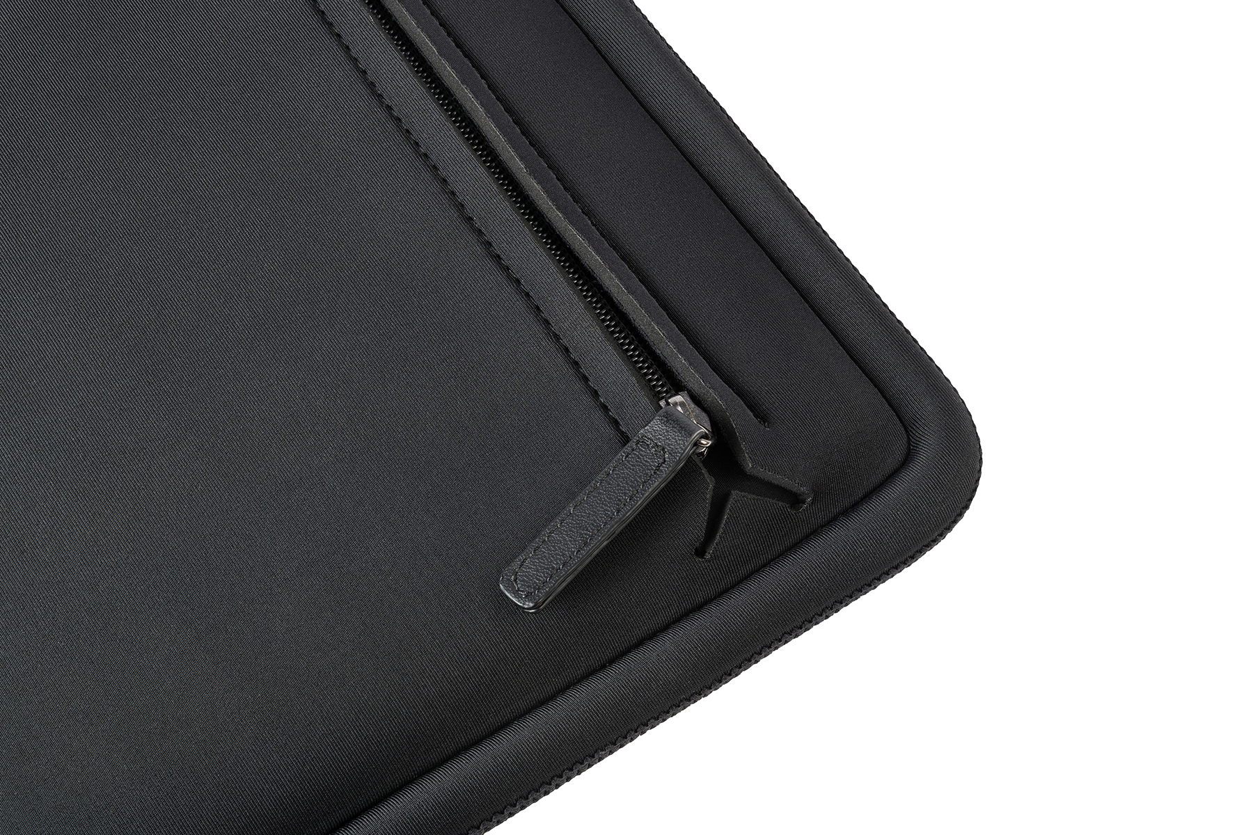 Naheinstellung einer schwarzen Tasche mit Reißverschluss und Ledergriff auf weißem Hintergrund.