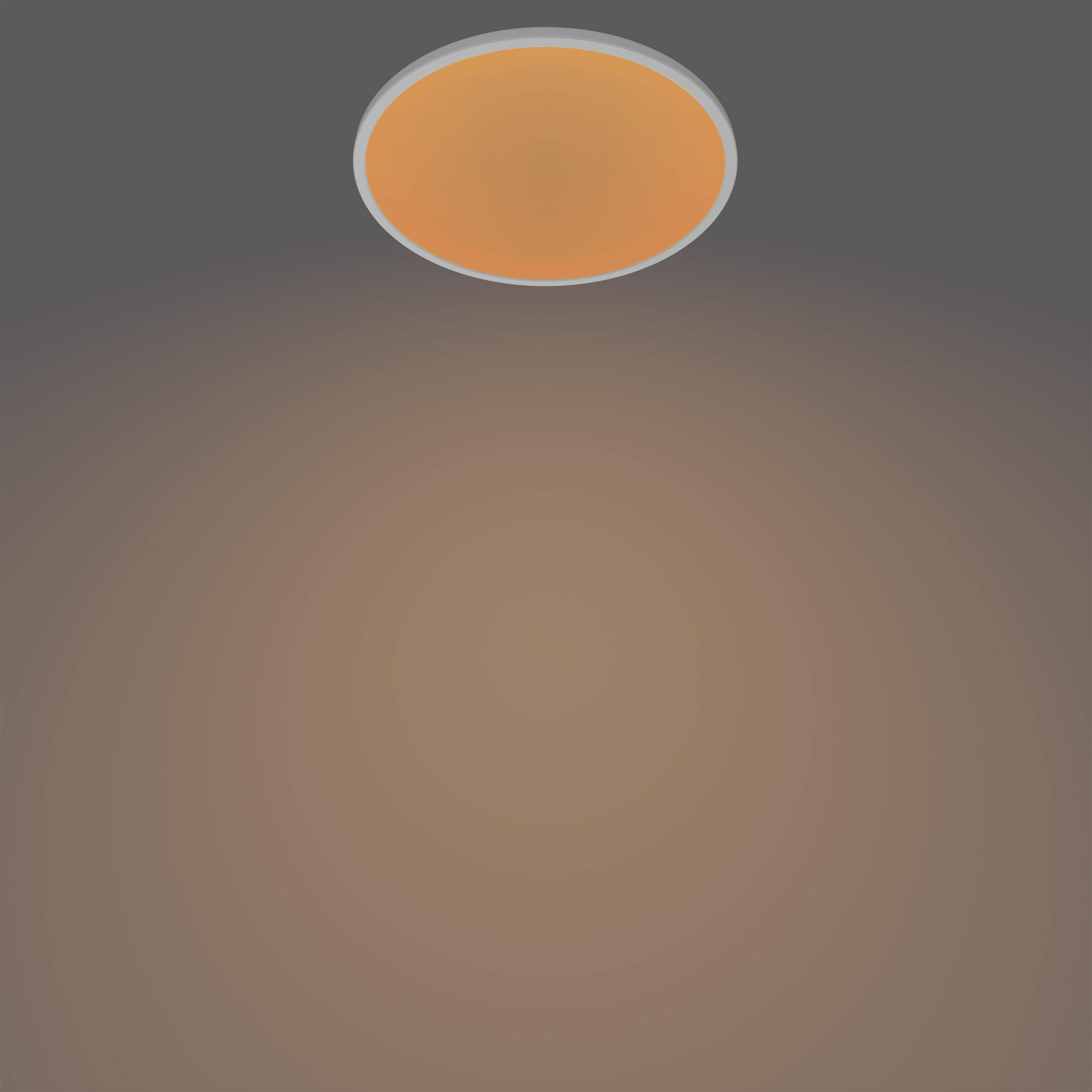 Eine runde, orangefarbene Lampe mit einem grauen Rand hängt an einer grauen Decke.