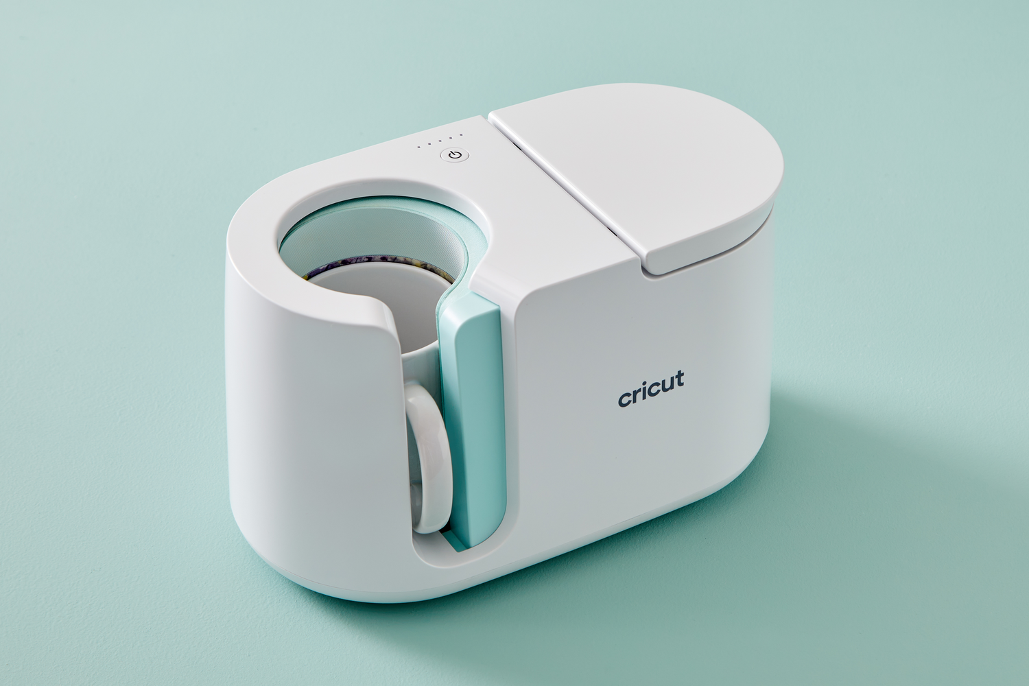 Una prensa de tazas Cricut blanca con asa y acento azul.
