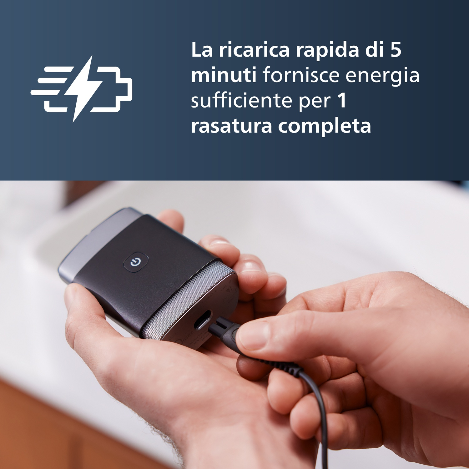 Un uomo collega un rasoio nero a un caricabatterie. Ricarica rapida.