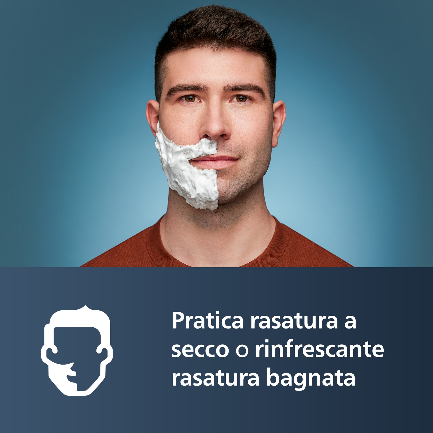 Uomo con metà viso coperto da schiuma da barba su sfondo blu.
