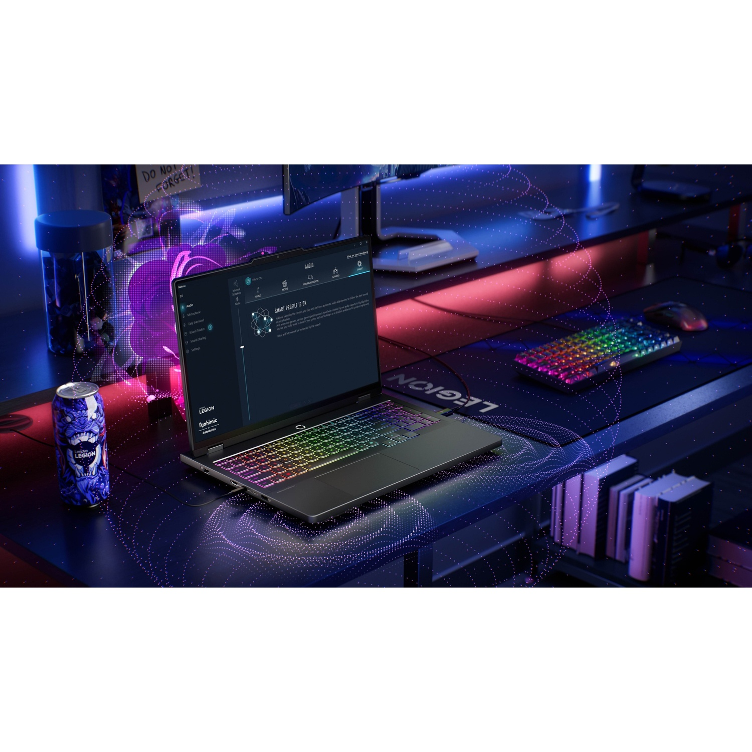 Un laptop da gaming con tastiera RGB, lattina, libri e mouse su una scrivania.