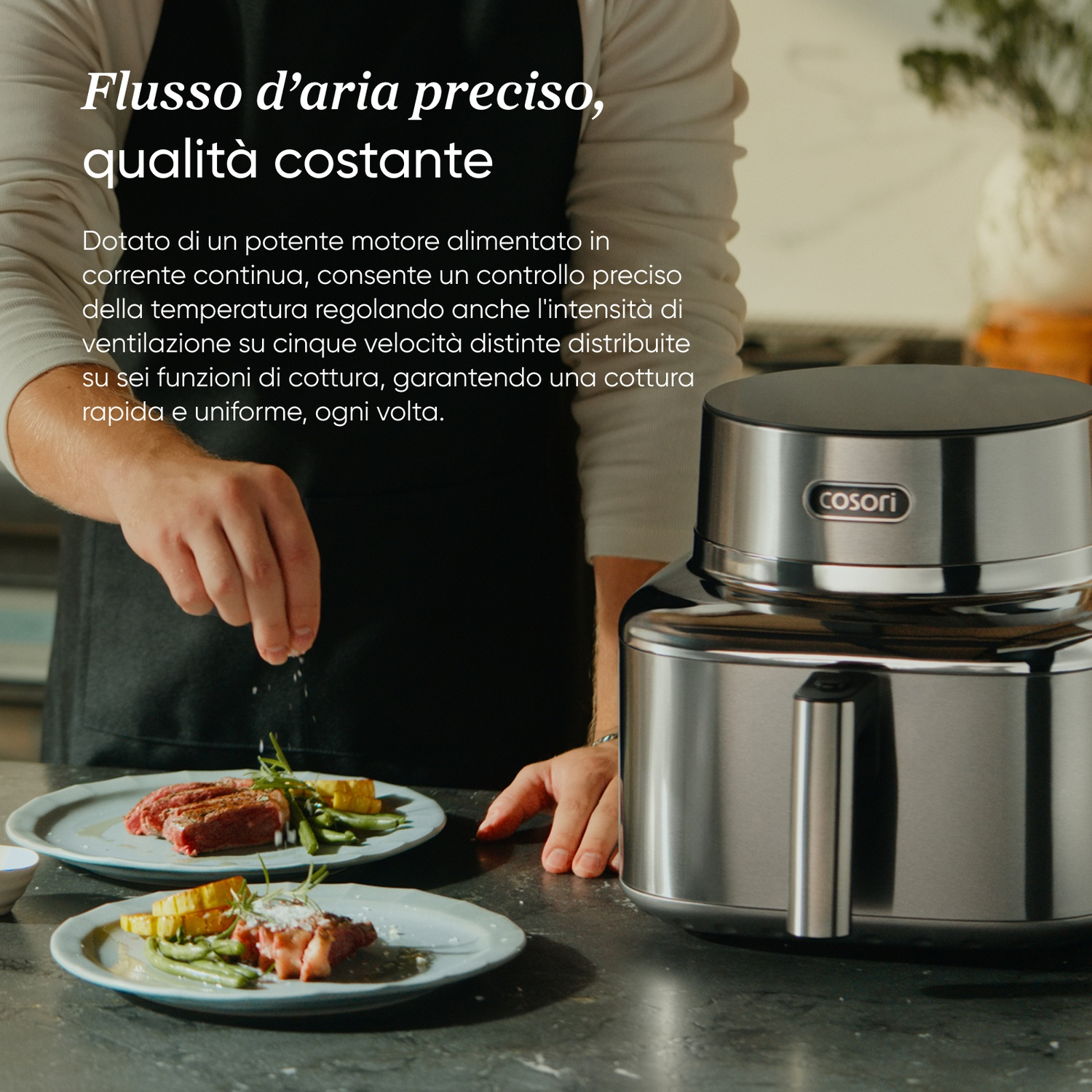 Un cuoco insaporisce bistecche su piatti con verdure accanto a un elettrodomestico argentato.