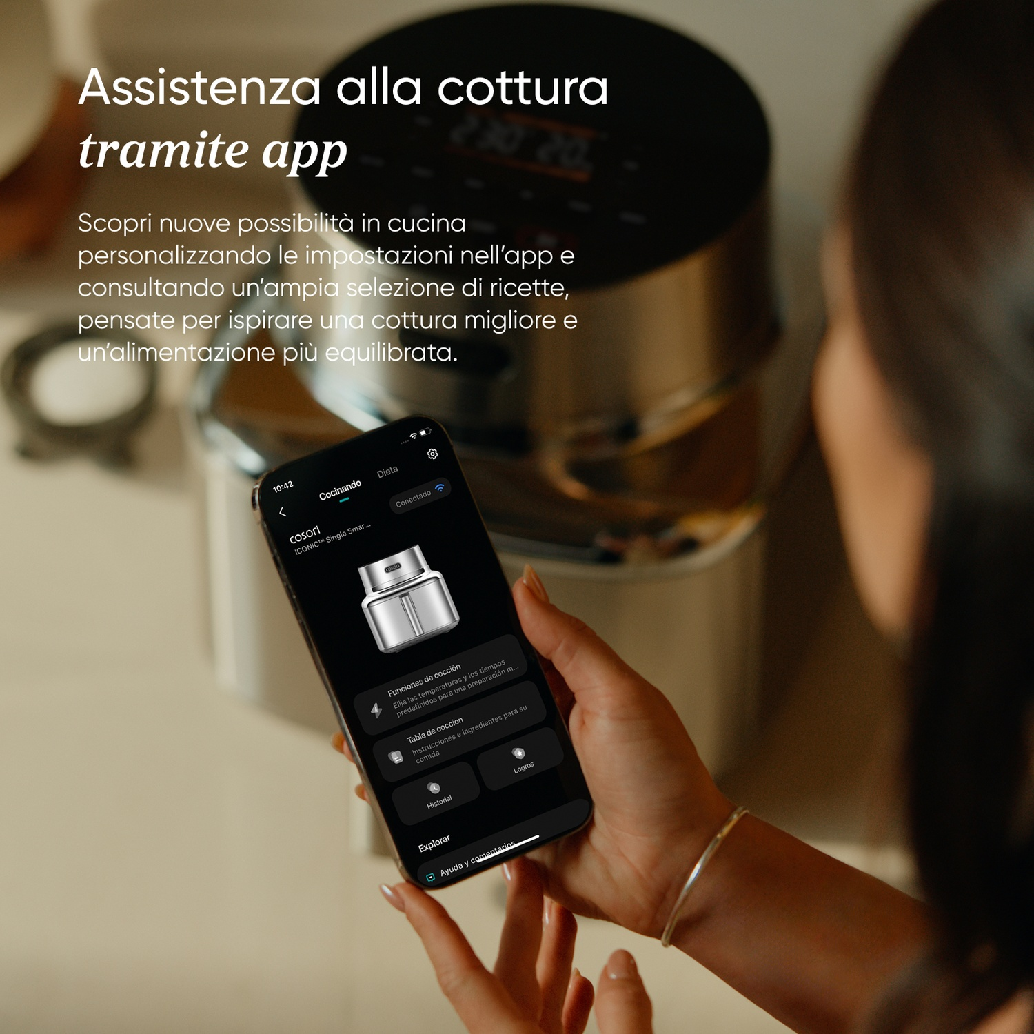 Una donna tiene uno smartphone con un'app di cucina. Un elettrodomestico da cucina sullo sfondo.