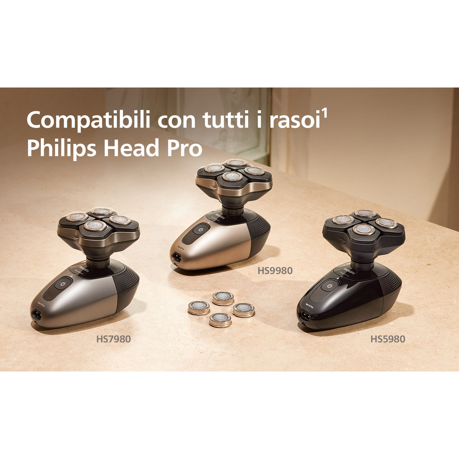 Tre rasoi Philips grigi, beige e neri su una superficie chiara.