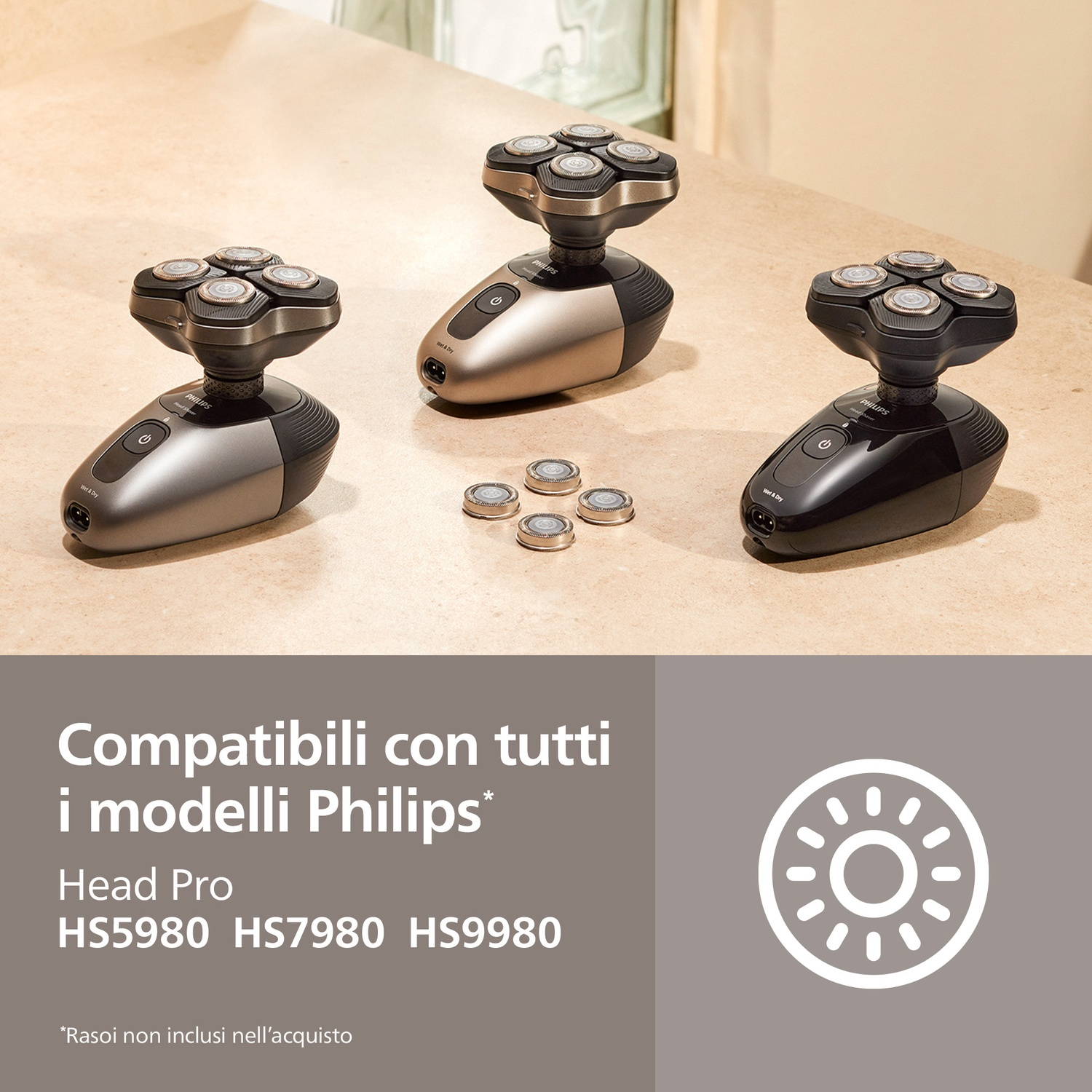 Tre rasoi Philips grigi, argento e neri su superficie in pietra. Testine di ricambio vicine.