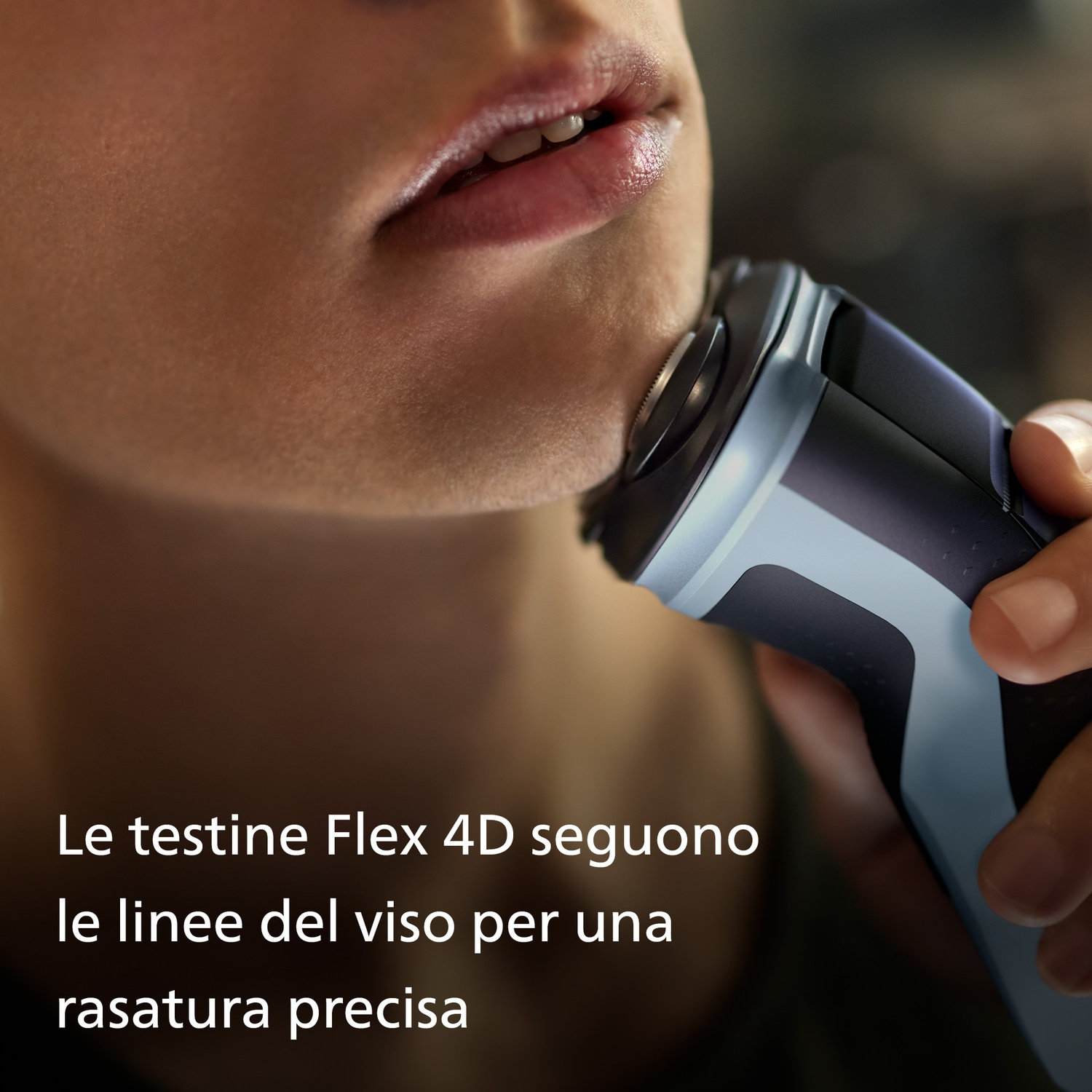 Persona che si rade il viso con un rasoio elettrico che segue i contorni del viso.