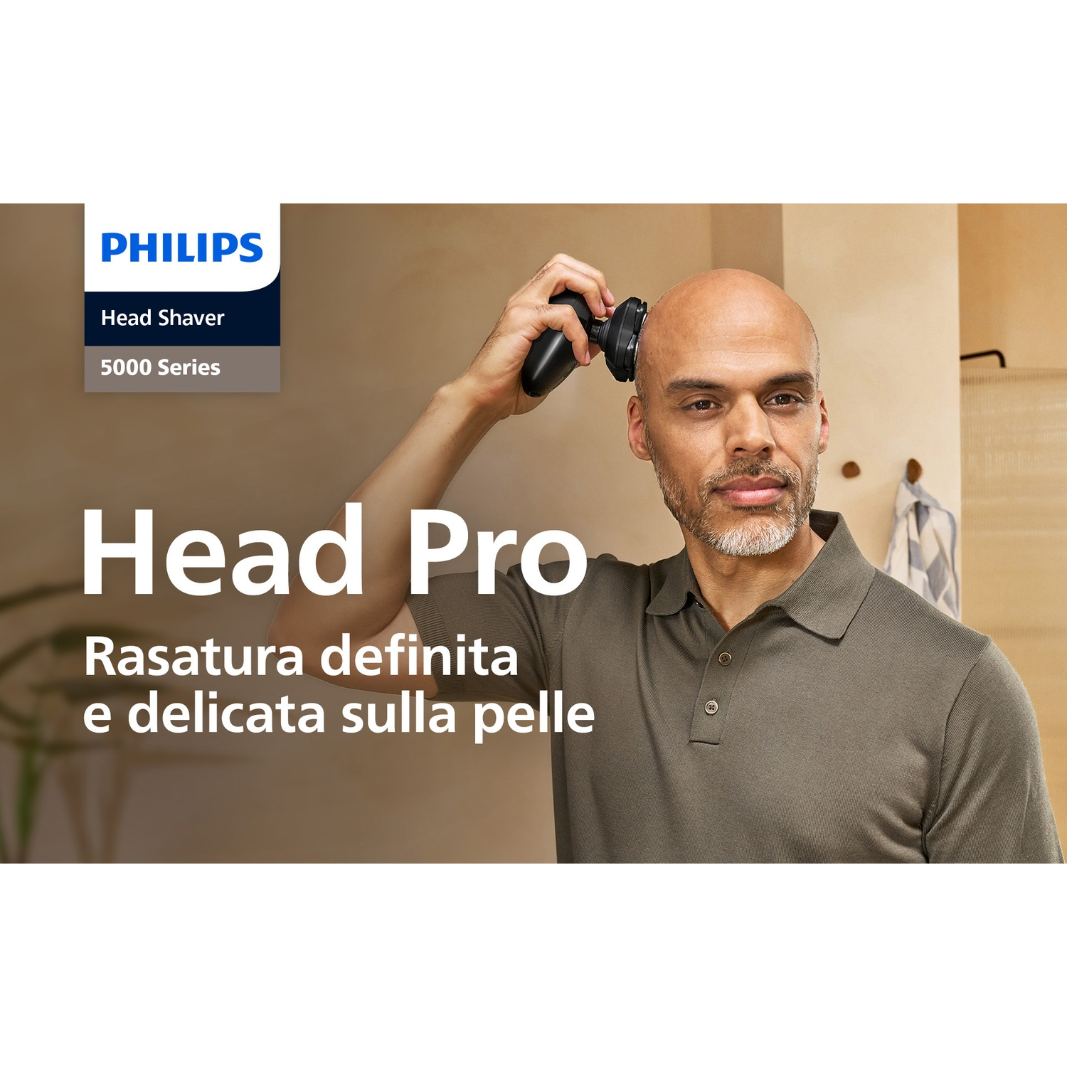 Uomo calvo si rade la testa con un rasoio Philips.