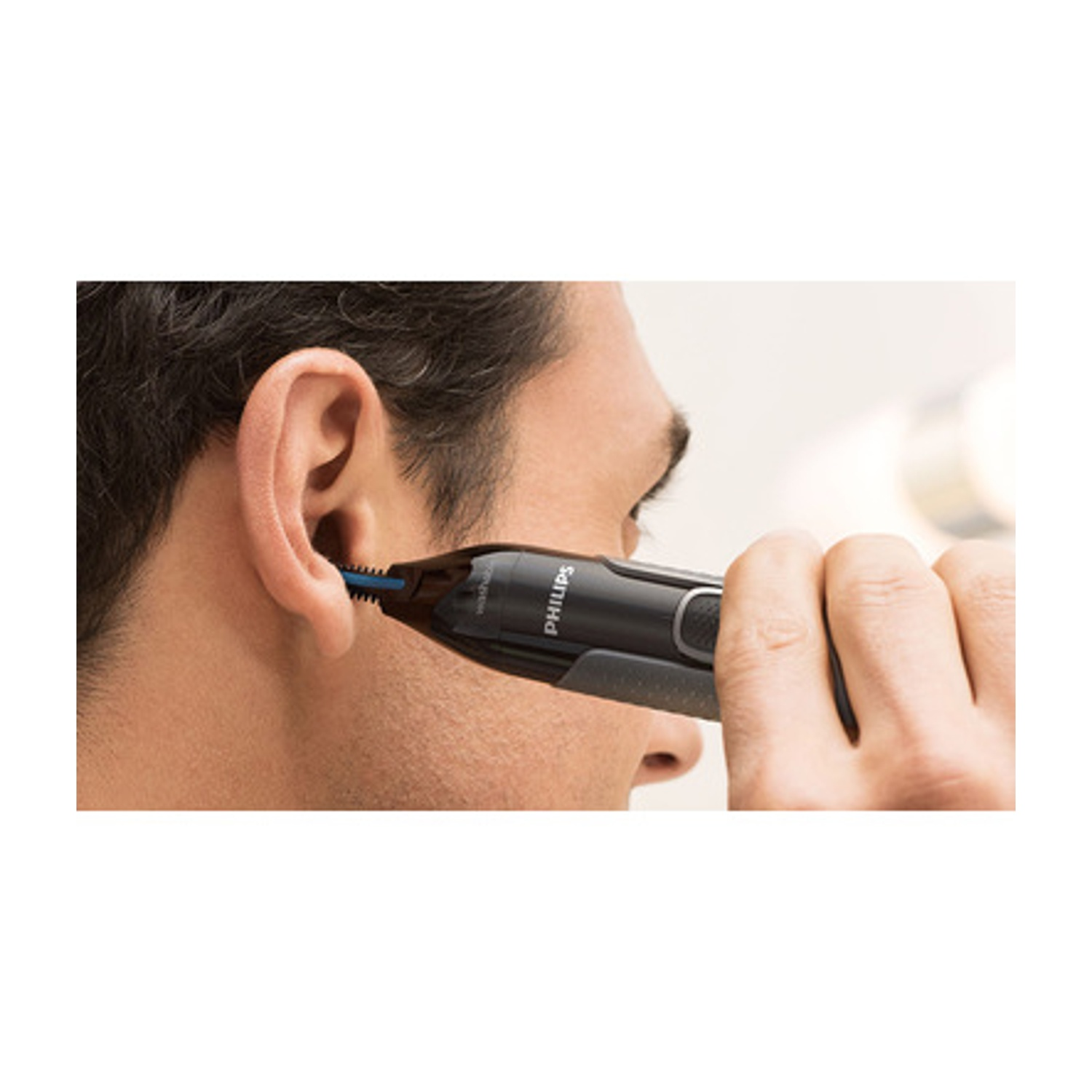 Uomo usa un rifinitore nasale Philips nero nel suo orecchio.
