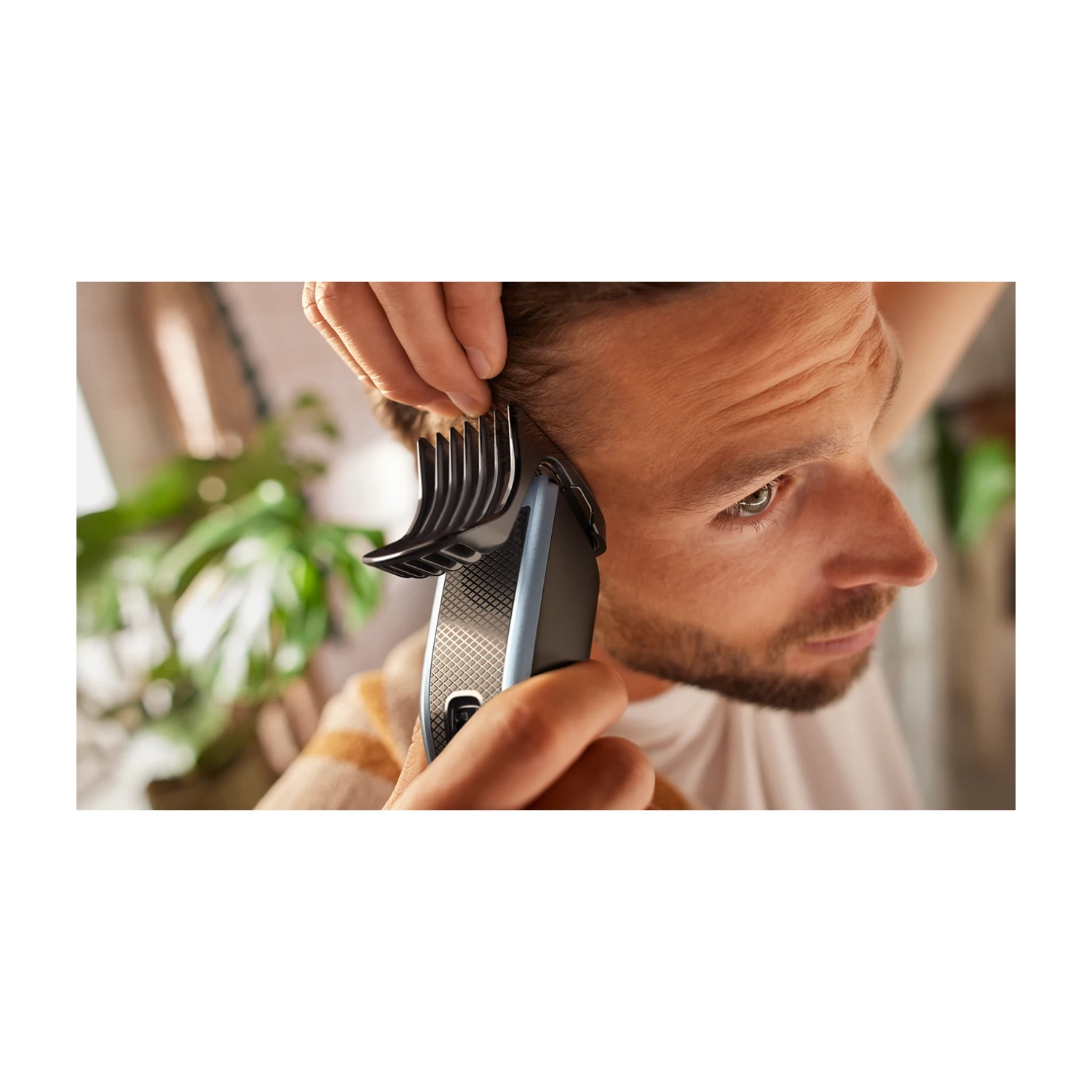 Uomo si taglia i capelli con un regolabarba elettrico e accessorio.