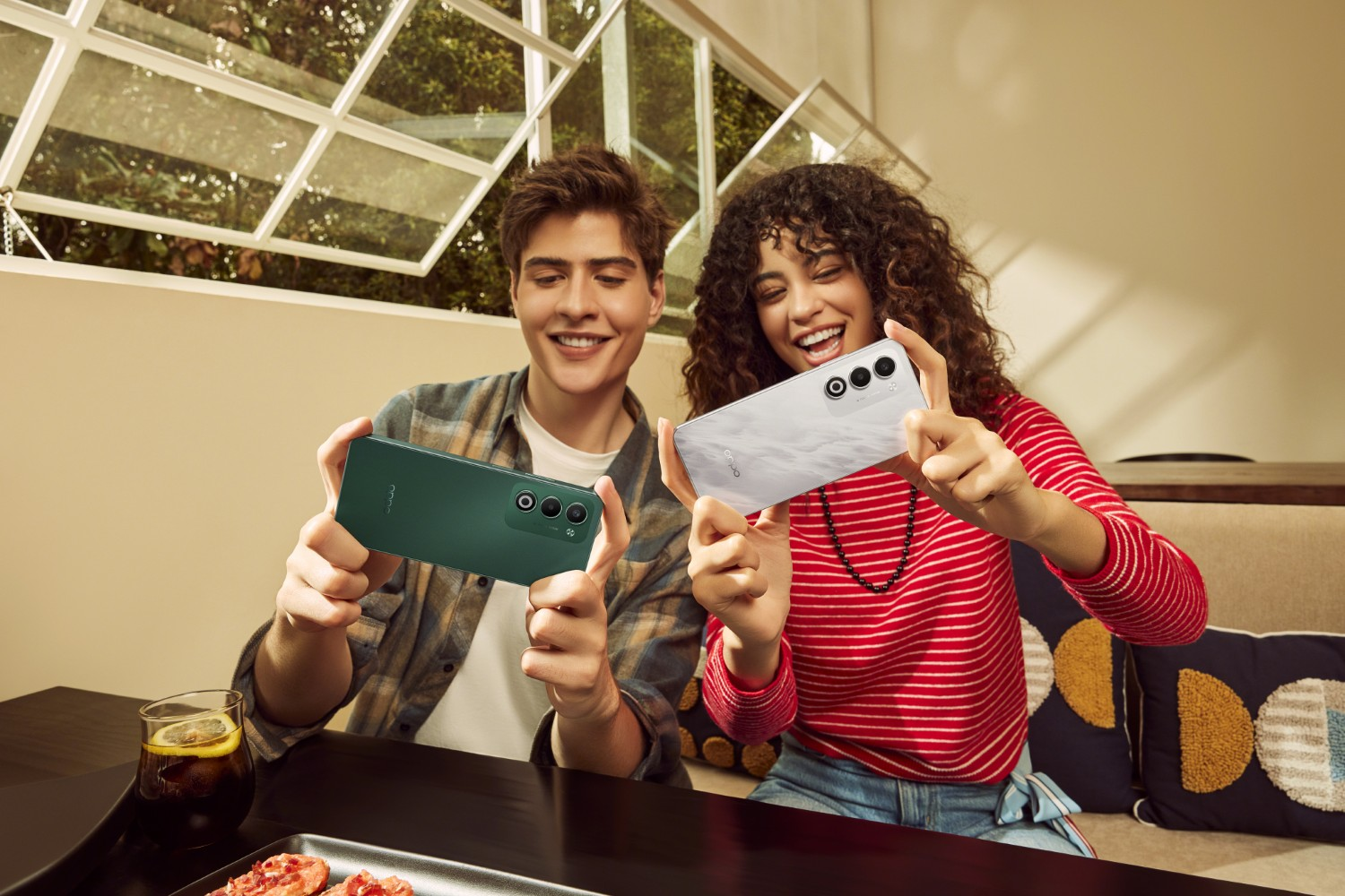 Mężczyzna i kobieta trzymają smartfony, mężczyzna zielony, kobieta biały. Na zewnątrz.