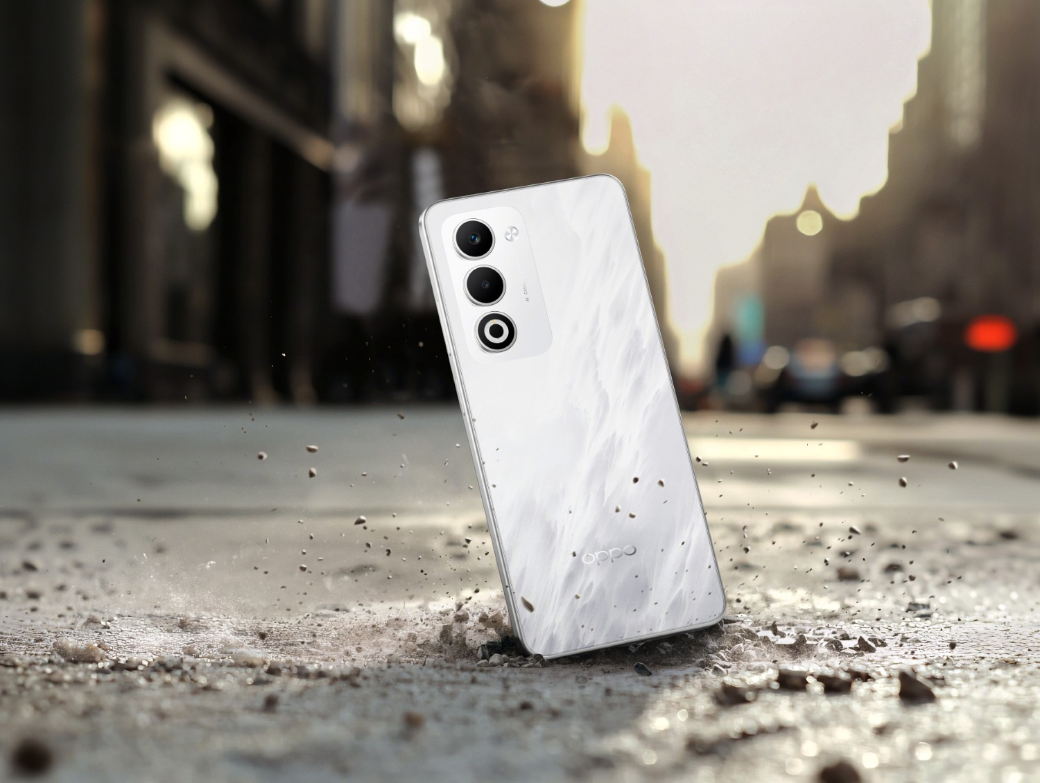 Biały smartfon z marmurowym wzorem leży na chodniku, otoczony gruzem.