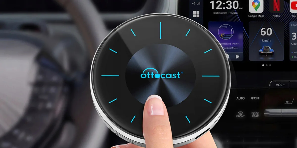 Ręka naciska urządzenie Ottocast przed ekranem systemu infotainment samochodu.