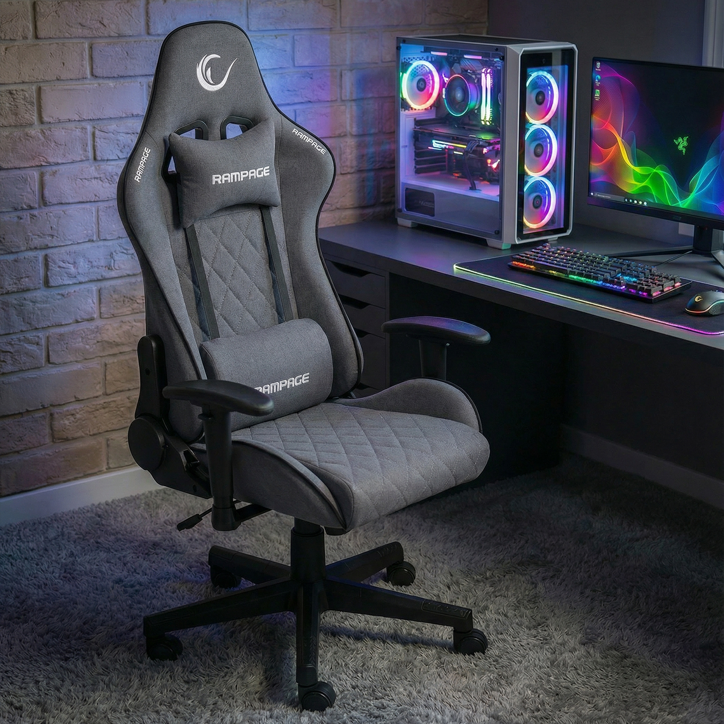 Aydınlatmalı PC ve monitörlü bir masanın önünde gri oyuncu koltuğu.