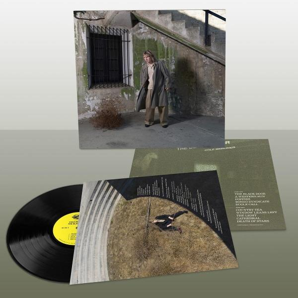 Ein Mann steht neben einer Treppe; daneben ein Vinyl-Album.