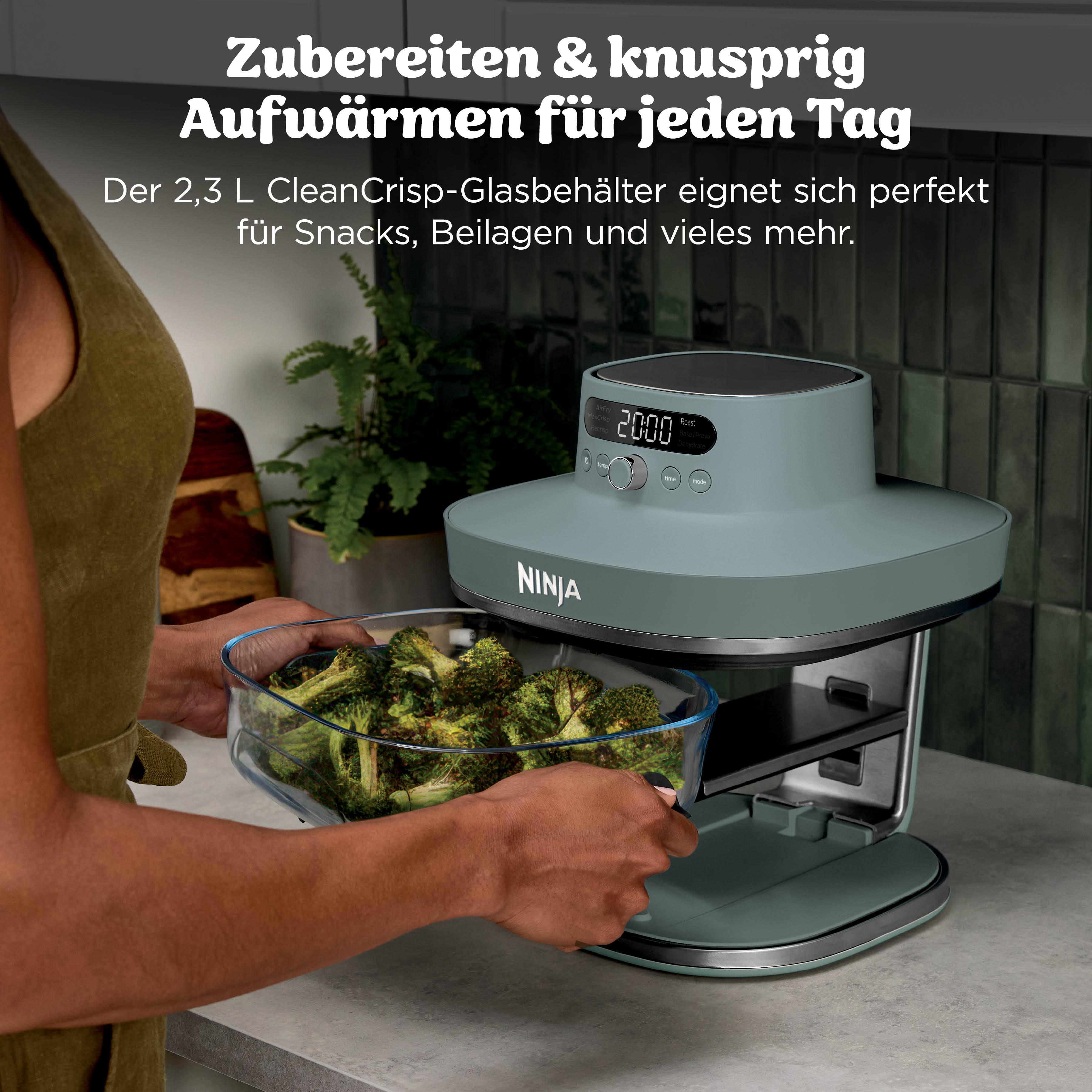 Eine Person legt eine Glasschüssel mit Brokkoli in einen grauen Ninja Airfryer.