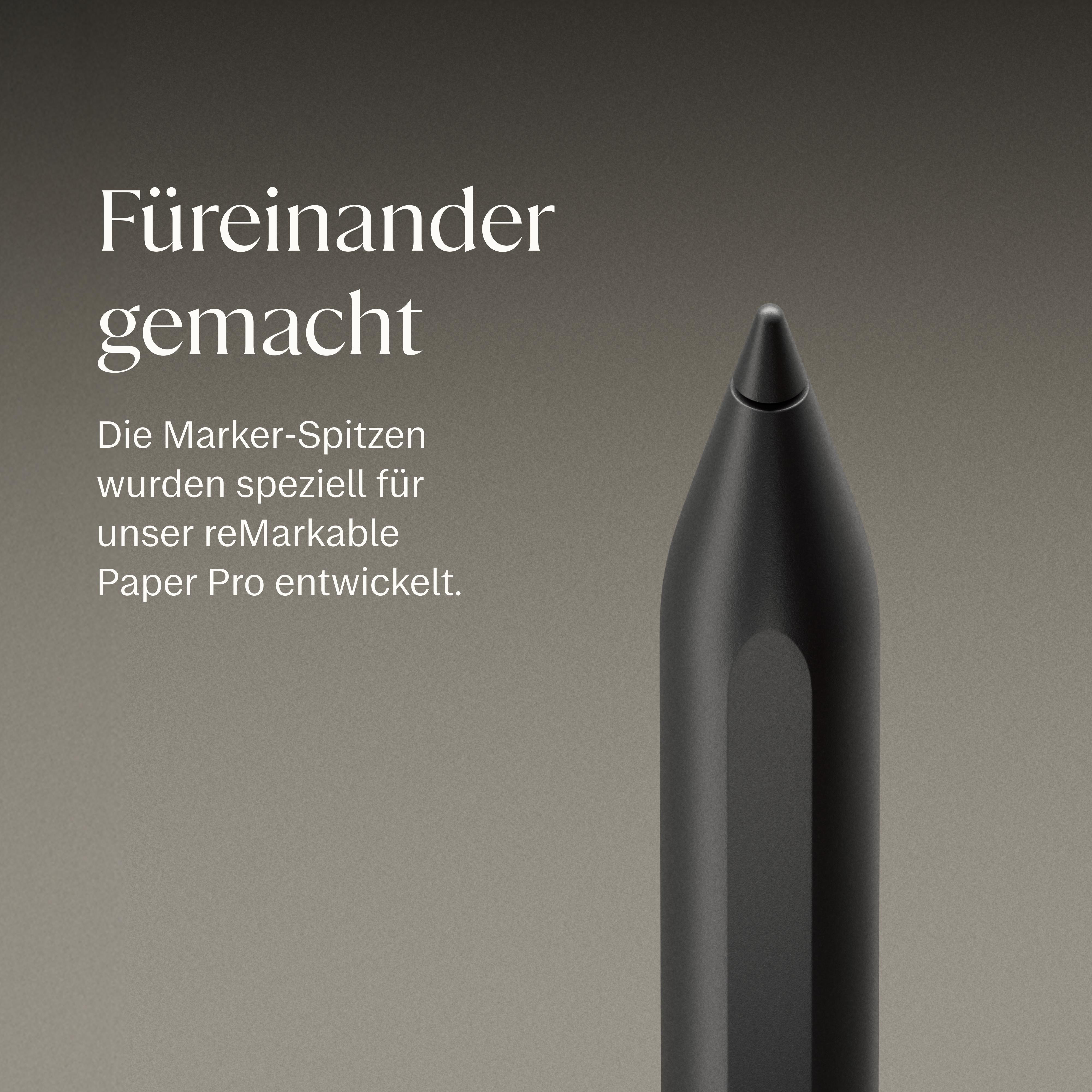 Ein schwarzer Stift mit spitzer Spitze auf grauem Hintergrund.