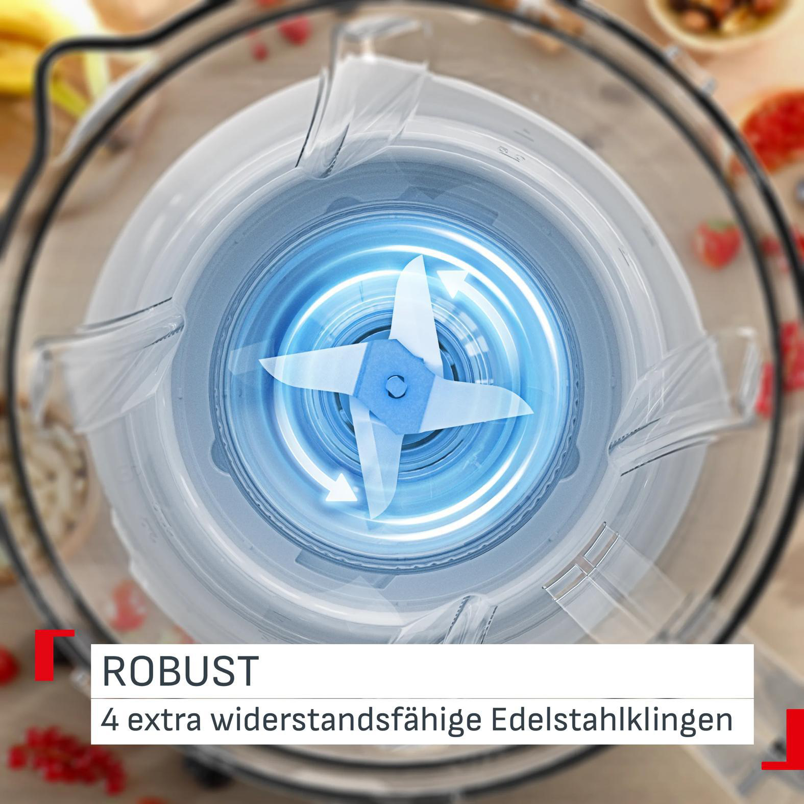 Ein Mixer mit vier Edelstahlklingen im Einsatz, umgeben von Früchten.