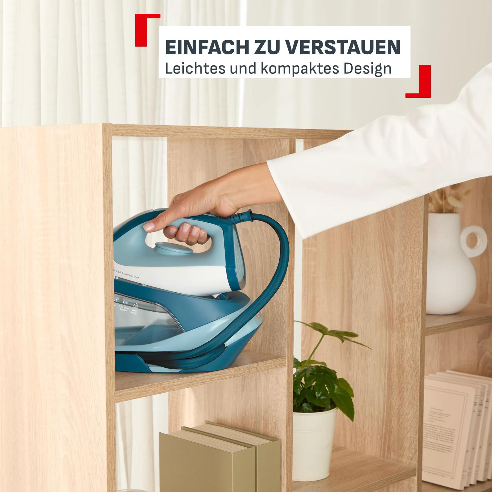 Eine Hand legt ein blaues Dampfbügeleisen in ein Holzregal.