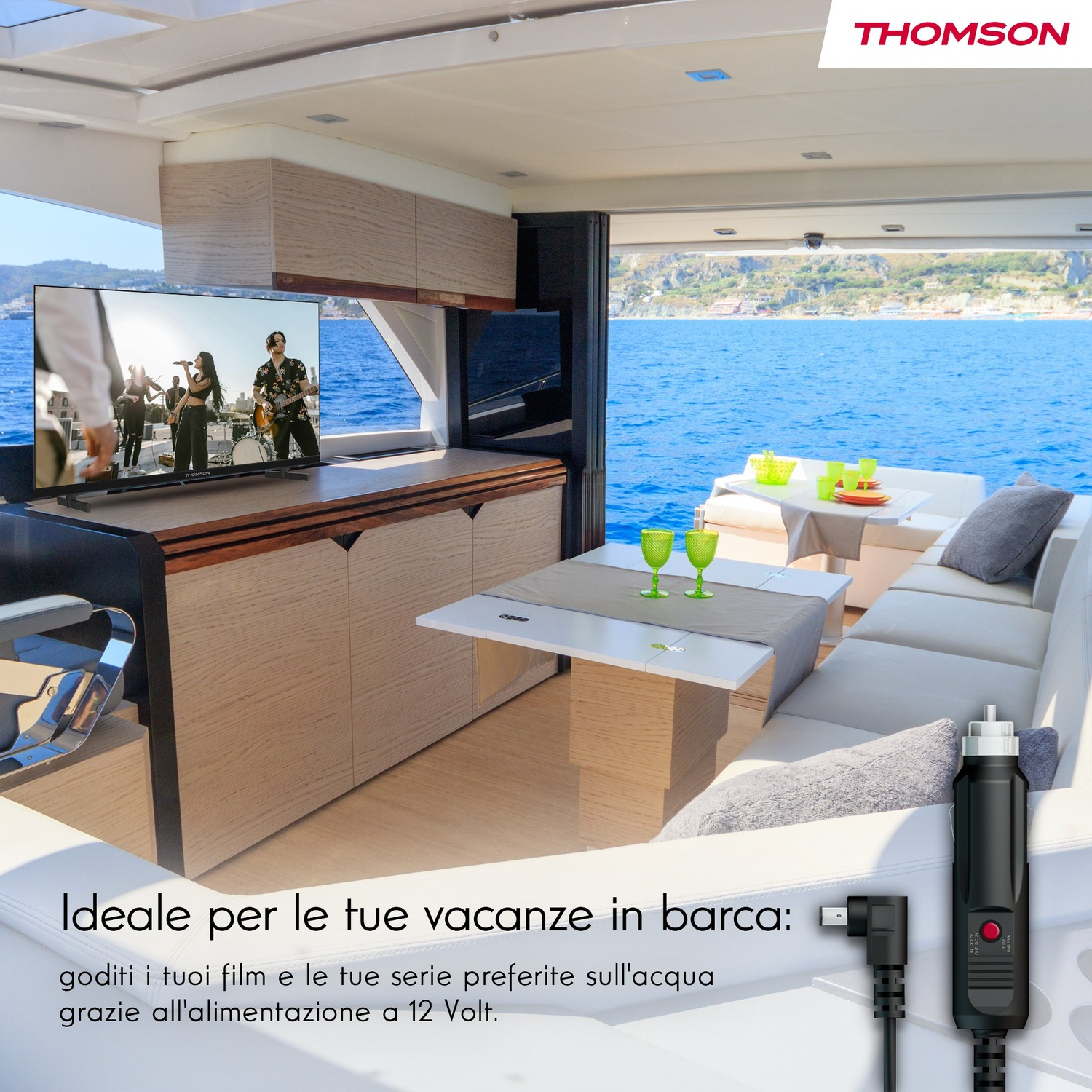 Interno moderno di barca con vista mare, TV mostra una band sul palco.