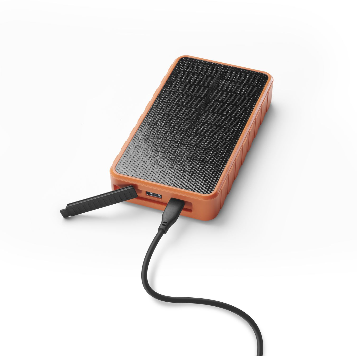 Batería externa naranja con panel solar negro, cable USB conectado.