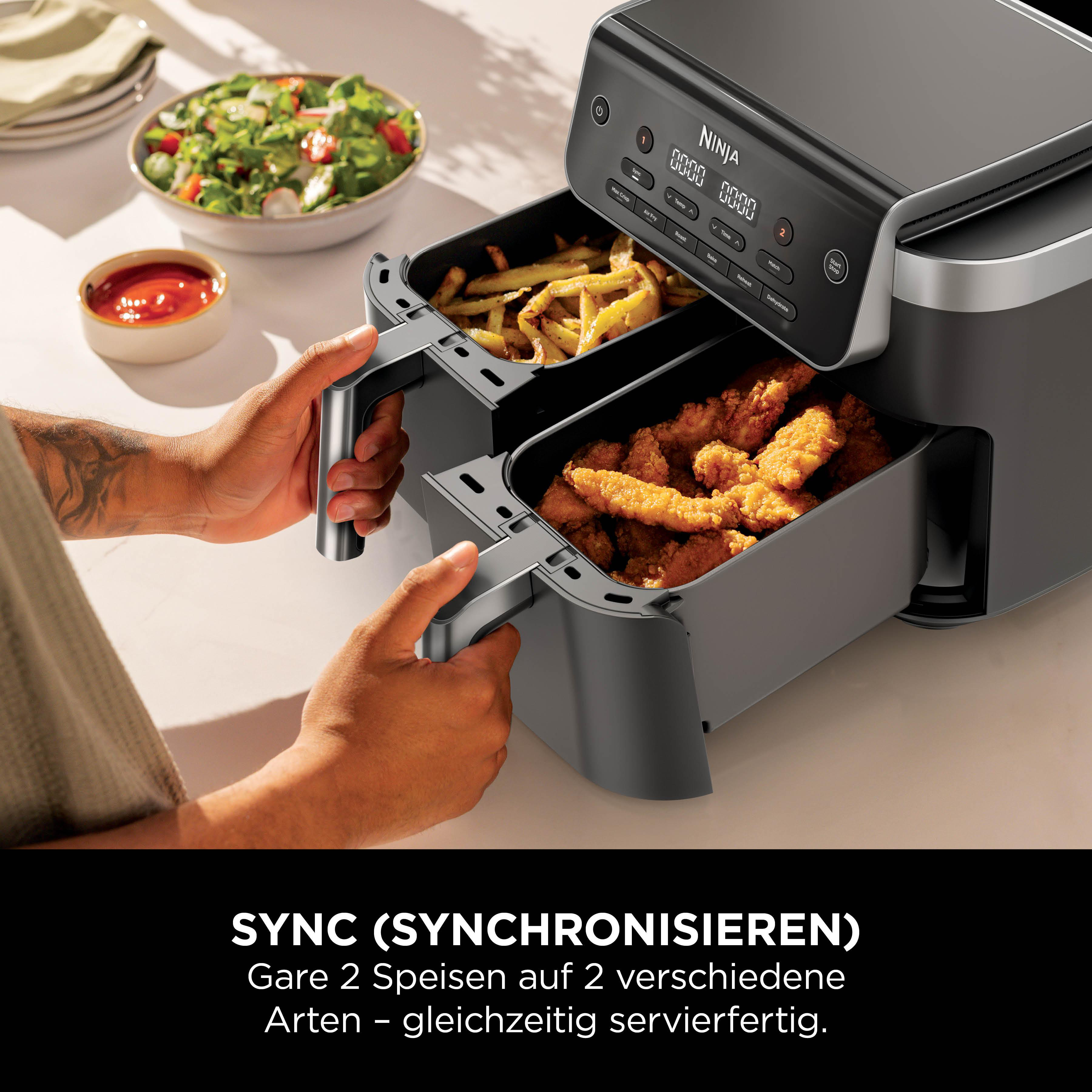 Ein schwarzer Ninja Dual Air Fryer mit Pommes und Hähnchen-Nuggets.
