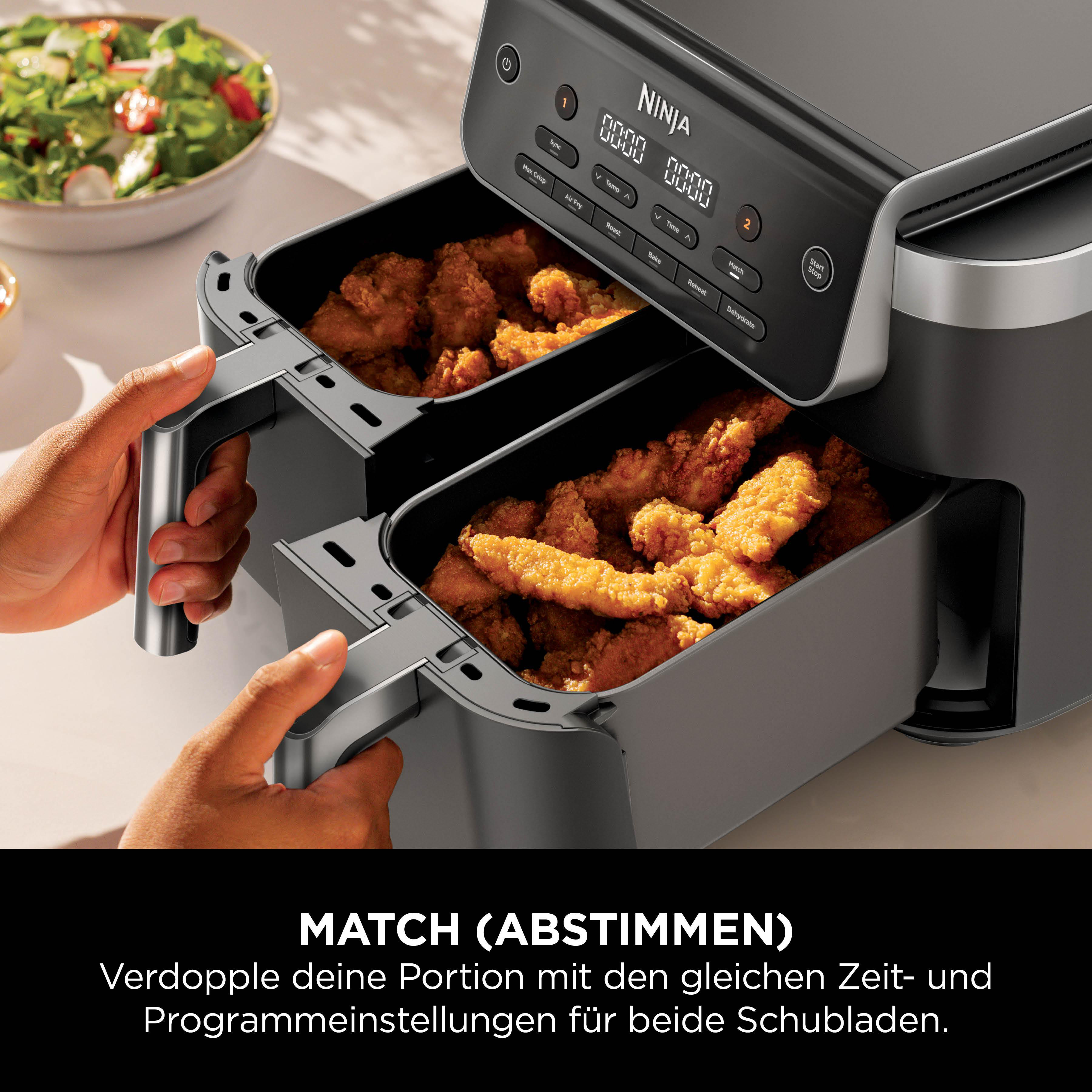 Ein schwarzer Ninja Air Fryer mit zwei Schubladen voller knuspriger Hähnchenstreifen.