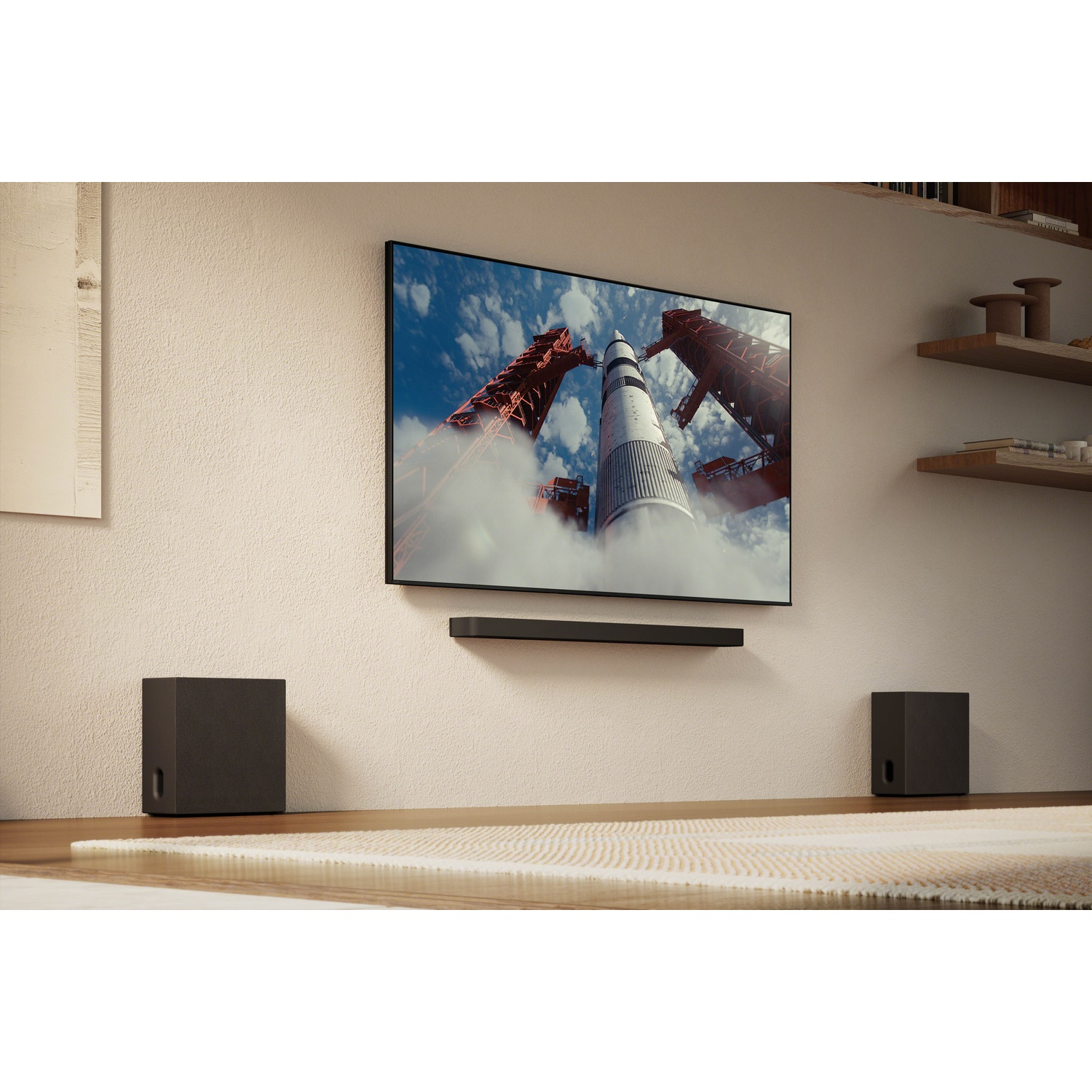 Une grande télévision affiche le lancement d'une fusée dans l'espace. Des subwoofers sont de chaque côté.
