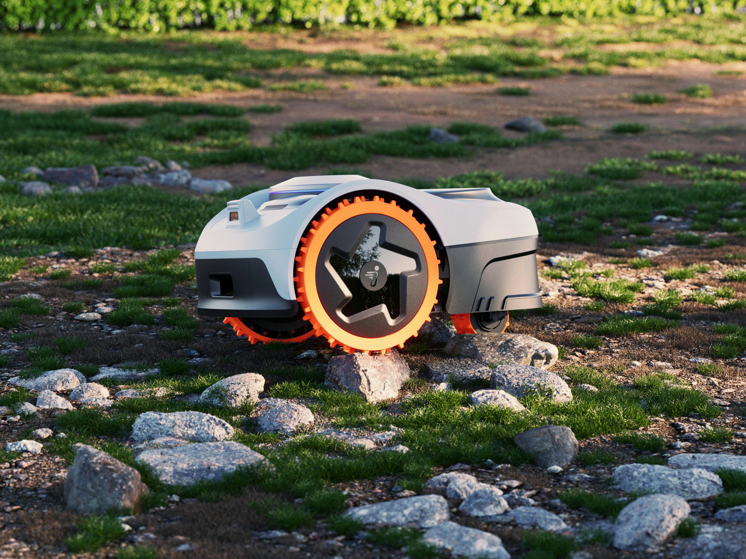 Ein weißer Mähroboter mit orangenen Rädern steht auf Gras und Steinen.