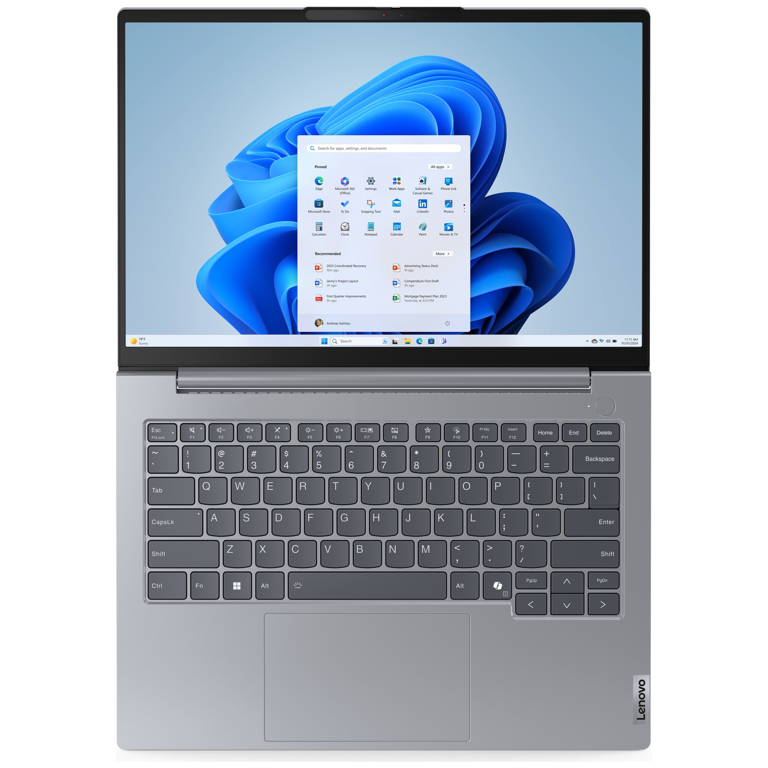 Een geopende zilveren Lenovo laptop met Windows 11 en een blauw behang.