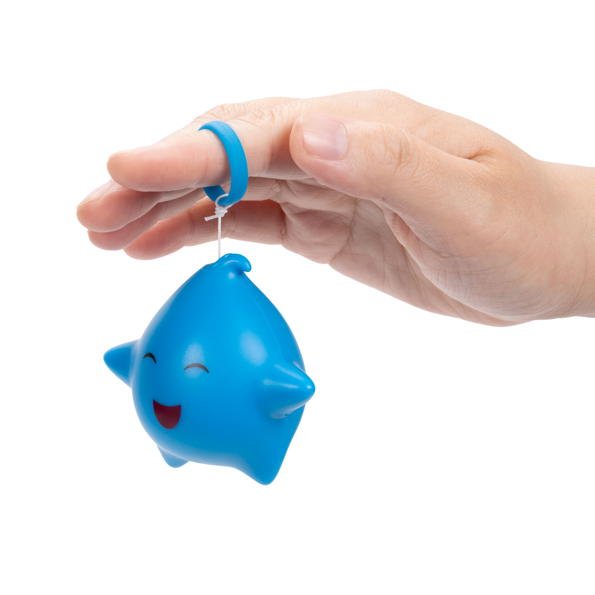 Eine blaue Delfinfigur mit Gesicht hängt an einem Finger, der einen blauen Ring trägt.
