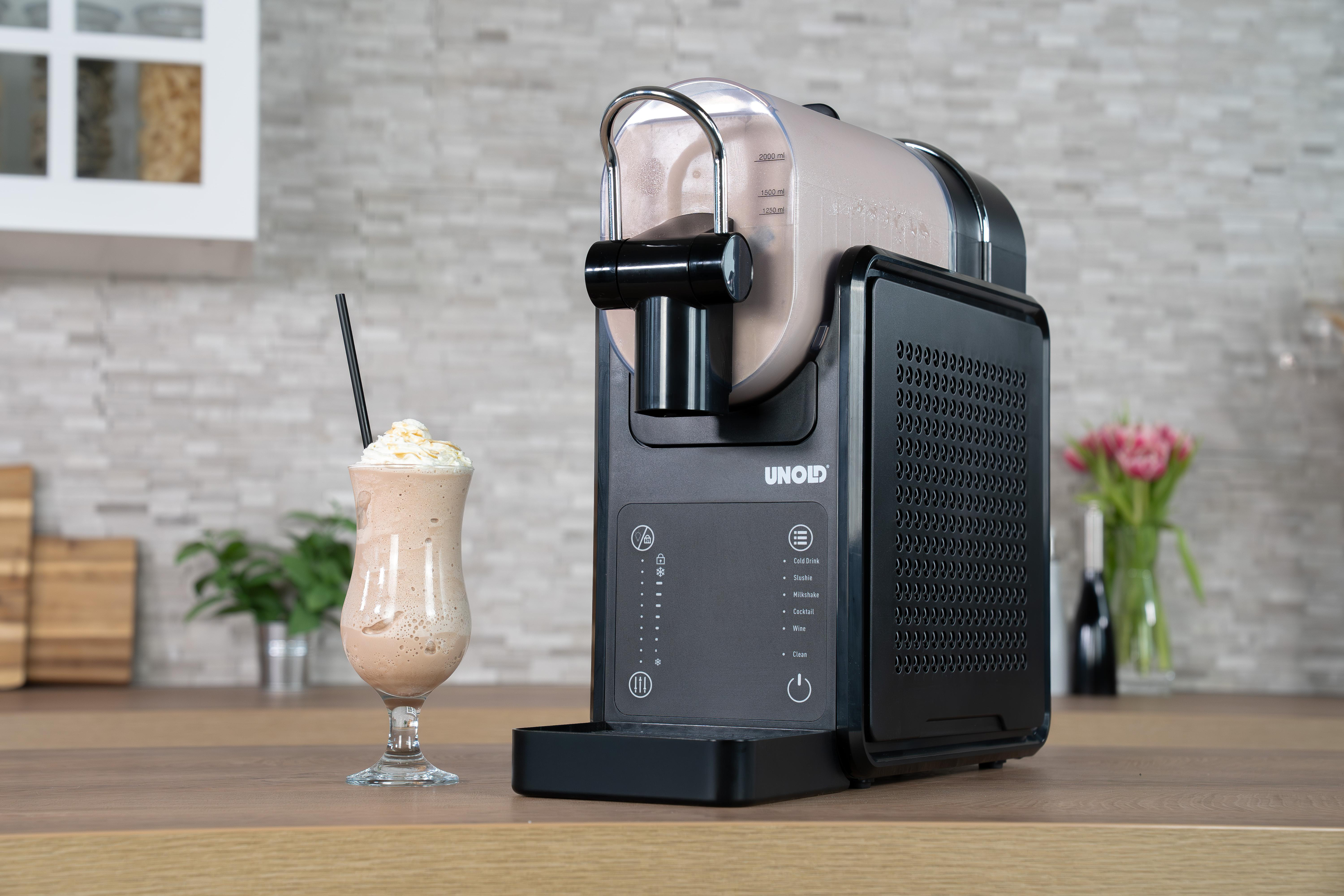 Ein Milchshake mit Sahne und Sirup neben einer schwarzen Eismaschine.