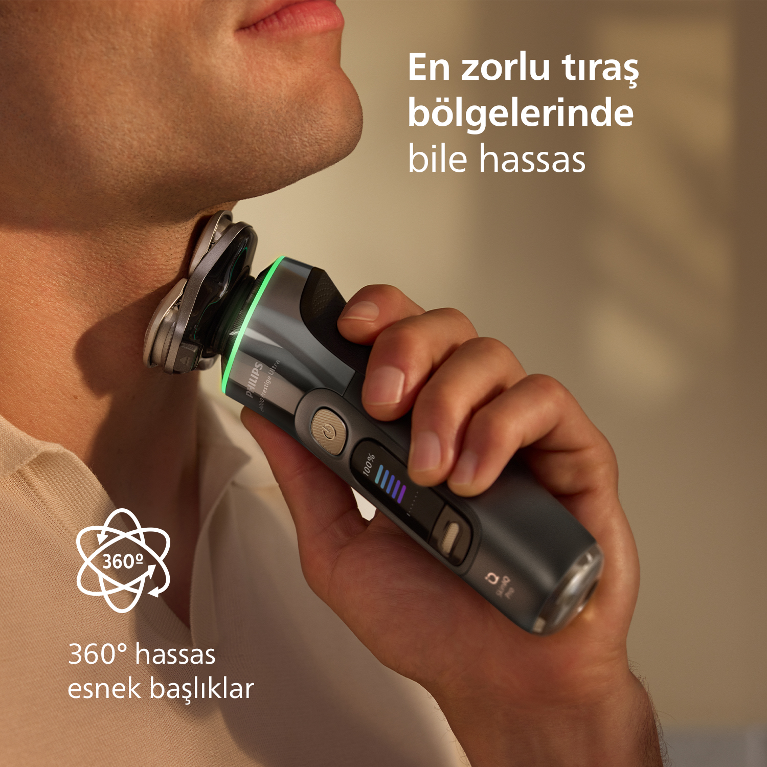 Erkek, boynunu yeşil ışıklı gri elektrikli tıraş makinesiyle tıraş ediyor.