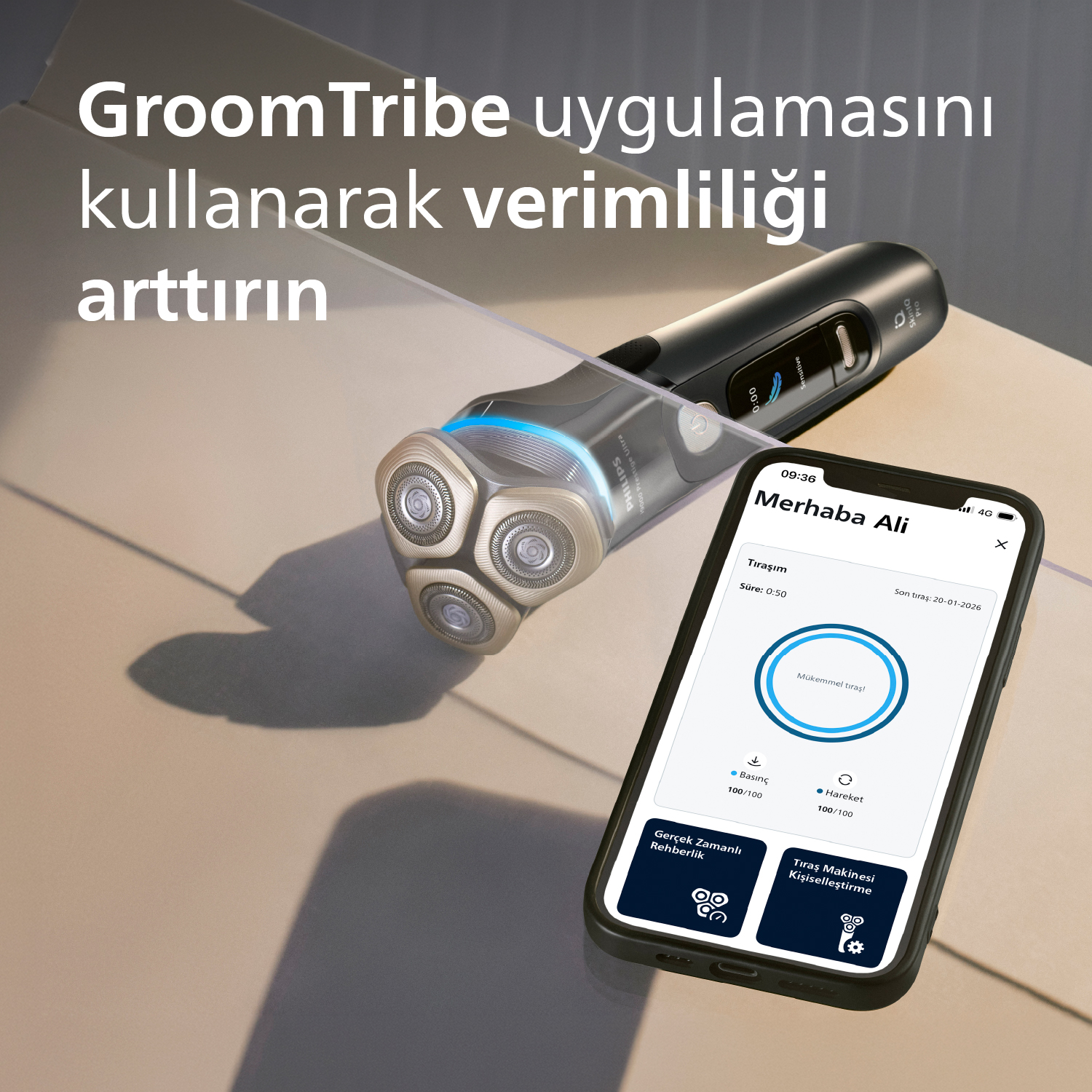 GroomTribe uygulamasını gösteren bir tıraş makinesi ve telefon.