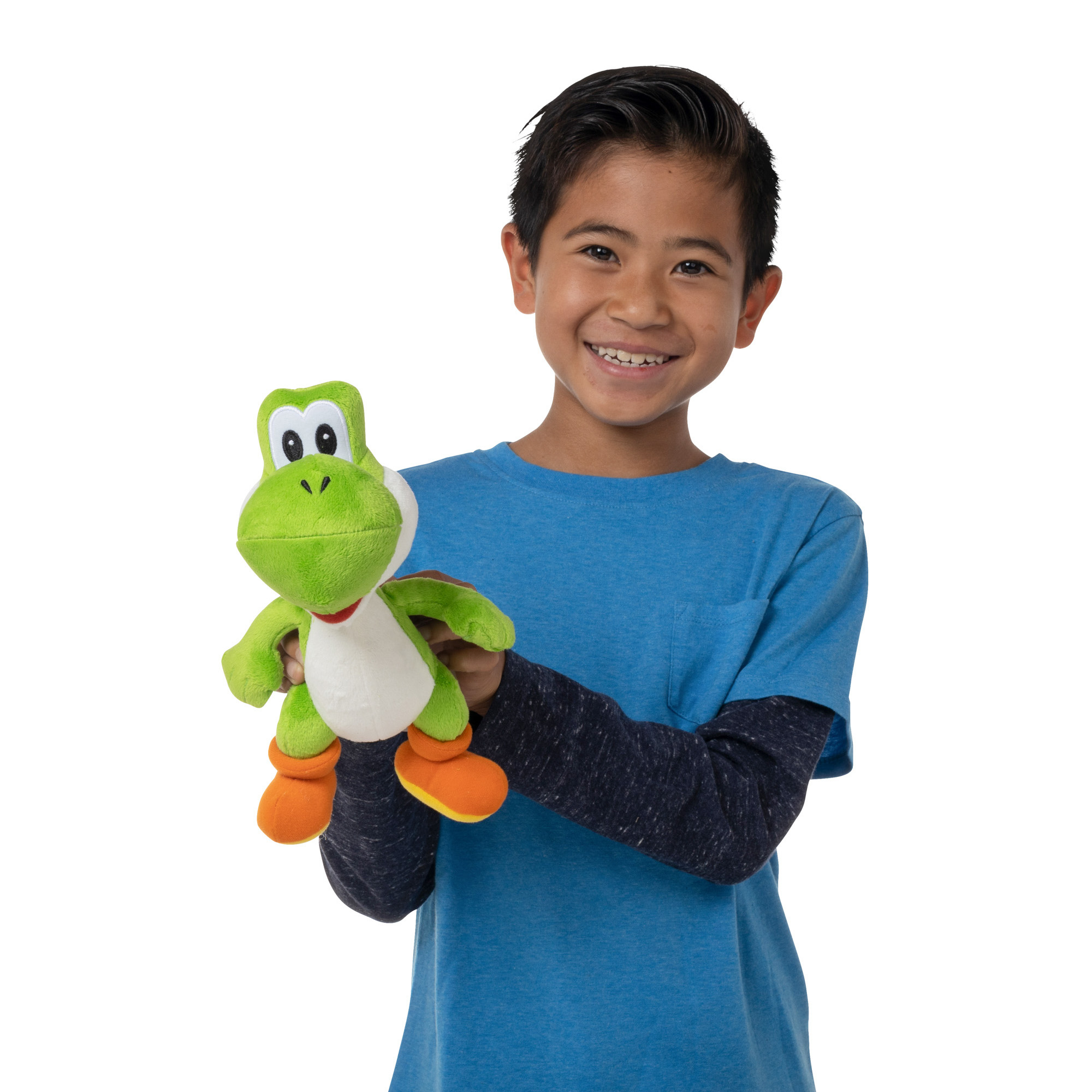 Ein Junge hält einen grünen Yoshi-Plüschtier vor einem weißen Hintergrund.