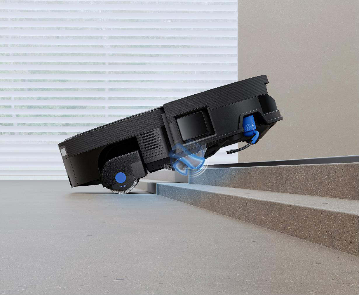 Ein schwarzer Saugroboter fährt auf eine Treppe zu.