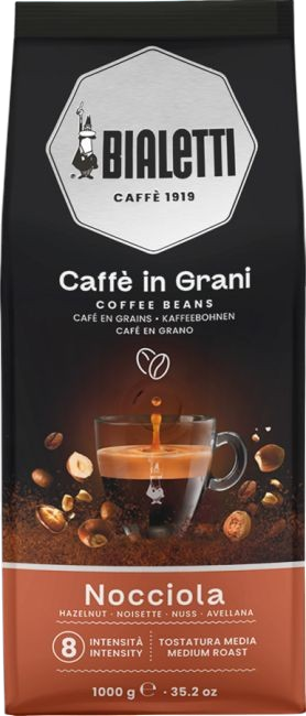 Bialetti Nocciola Kaffee in Grani. Espresso fließt in eine Tasse, umgeben von Haselnüssen.
