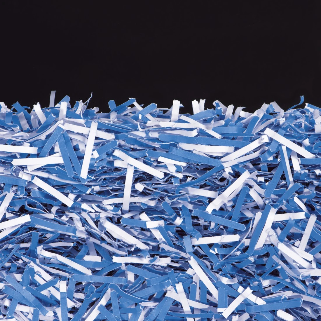 Montón de tiras de papel azules y blancas sobre fondo negro.