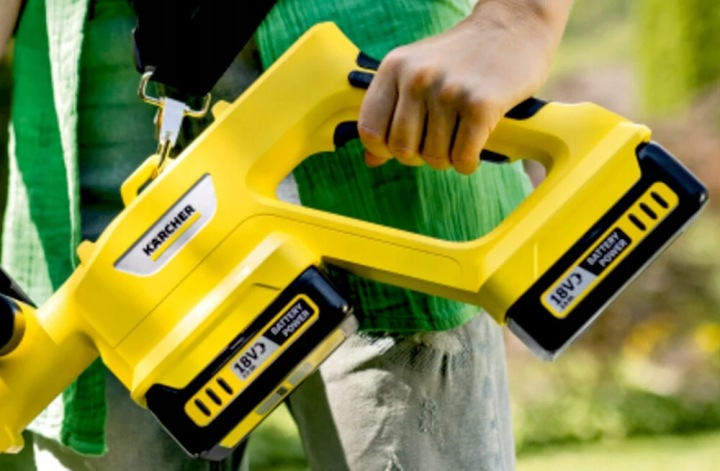 Żółte urządzenie Kärcher z dwoma akumulatorami 18V trzymane w dłoni.