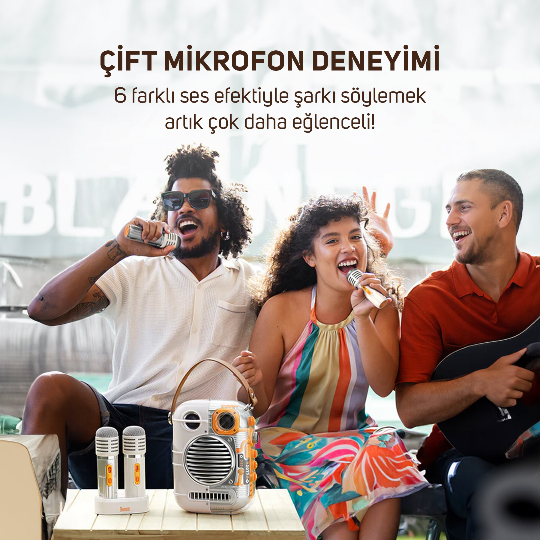Üç kişi mikrofonlarla şarkı söylüyor, bir adam gitar çalıyor. Önde hoparlör ve mikrofonlar.