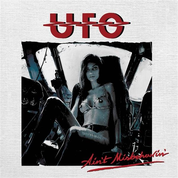 Frau im Bikini hält Waffe im Cockpit, UFO-Logo oben