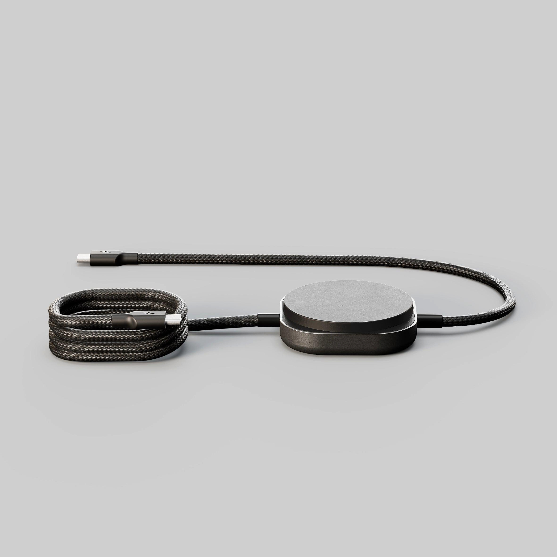 Ein schwarzes Ladekabel mit USB-C-Anschluss liegt auf grauem Untergrund.