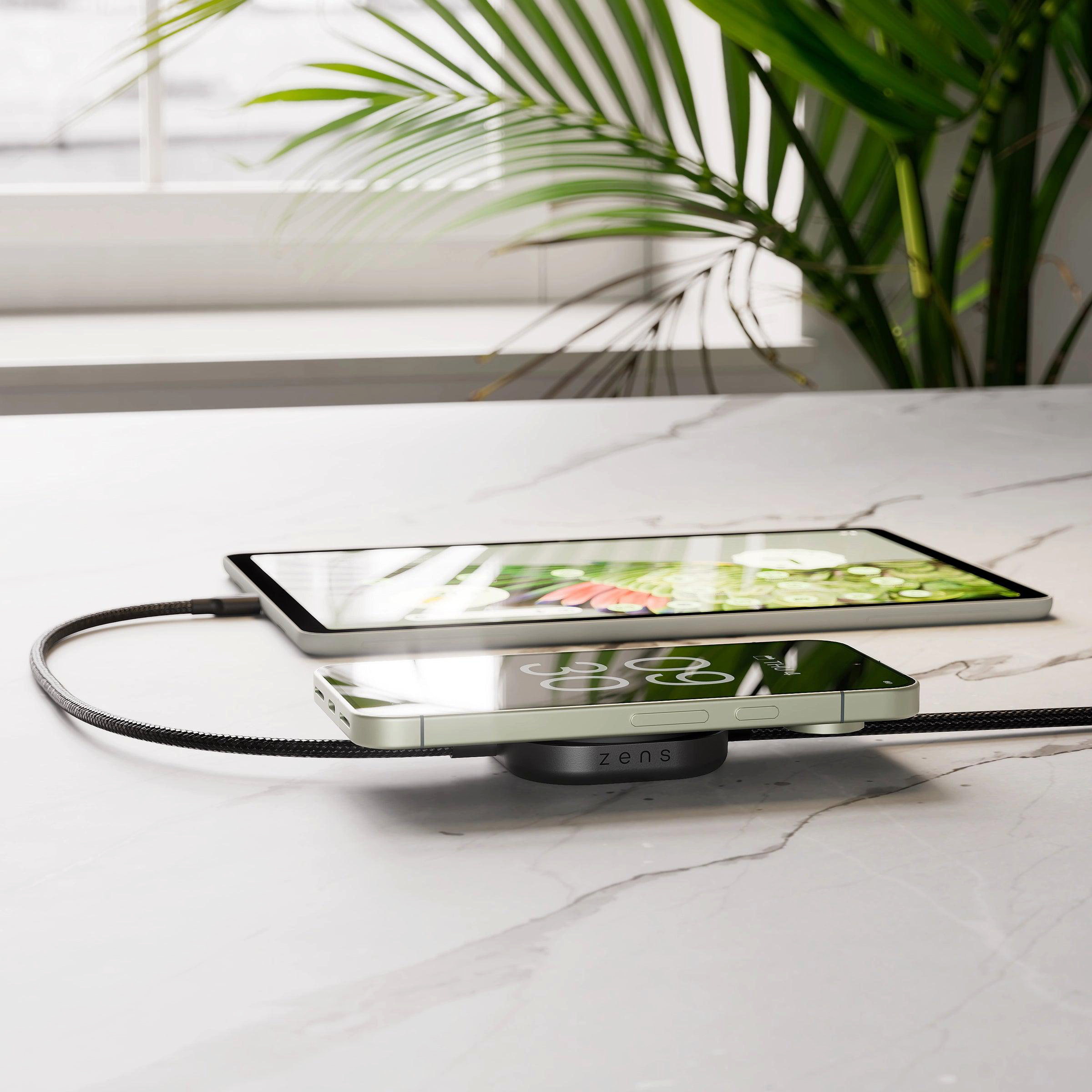Ein iPhone und ein Tablet laden auf einer Marmoroberfläche.