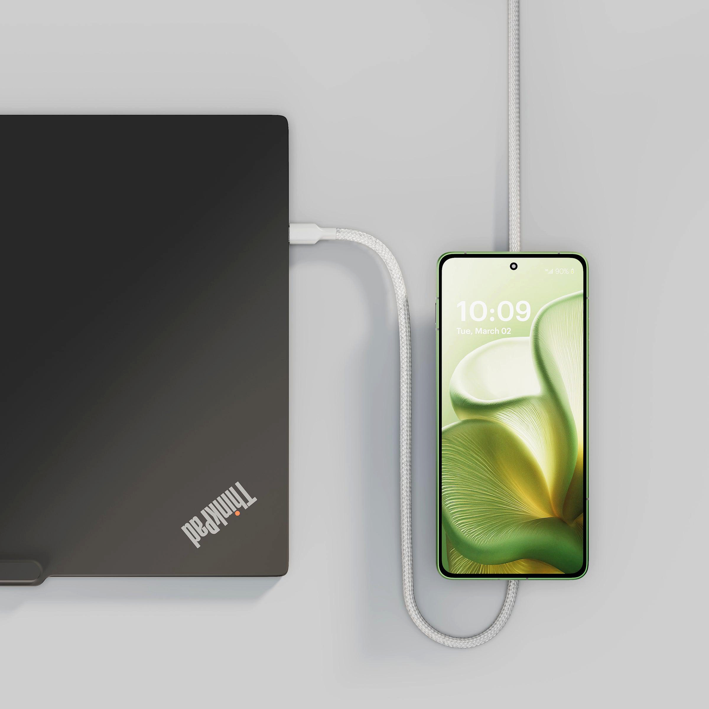 Ein schwarzer Laptop ist mit einem weißen Kabel mit einem grünen Smartphone verbunden.