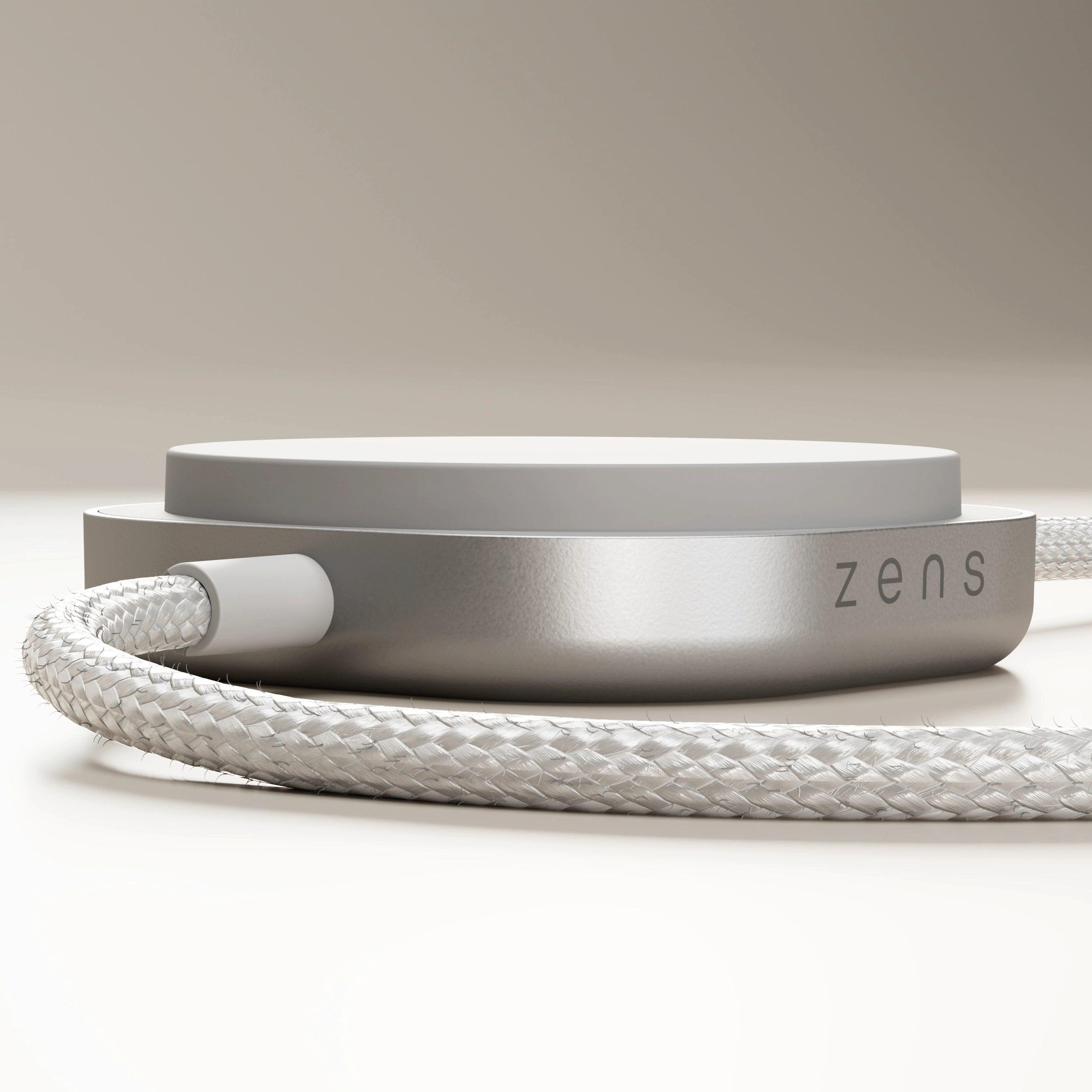 Ein weißes, geflochtenes Kabel verbindet sich mit einem silbernen Gerät mit der Aufschrift „zens“.